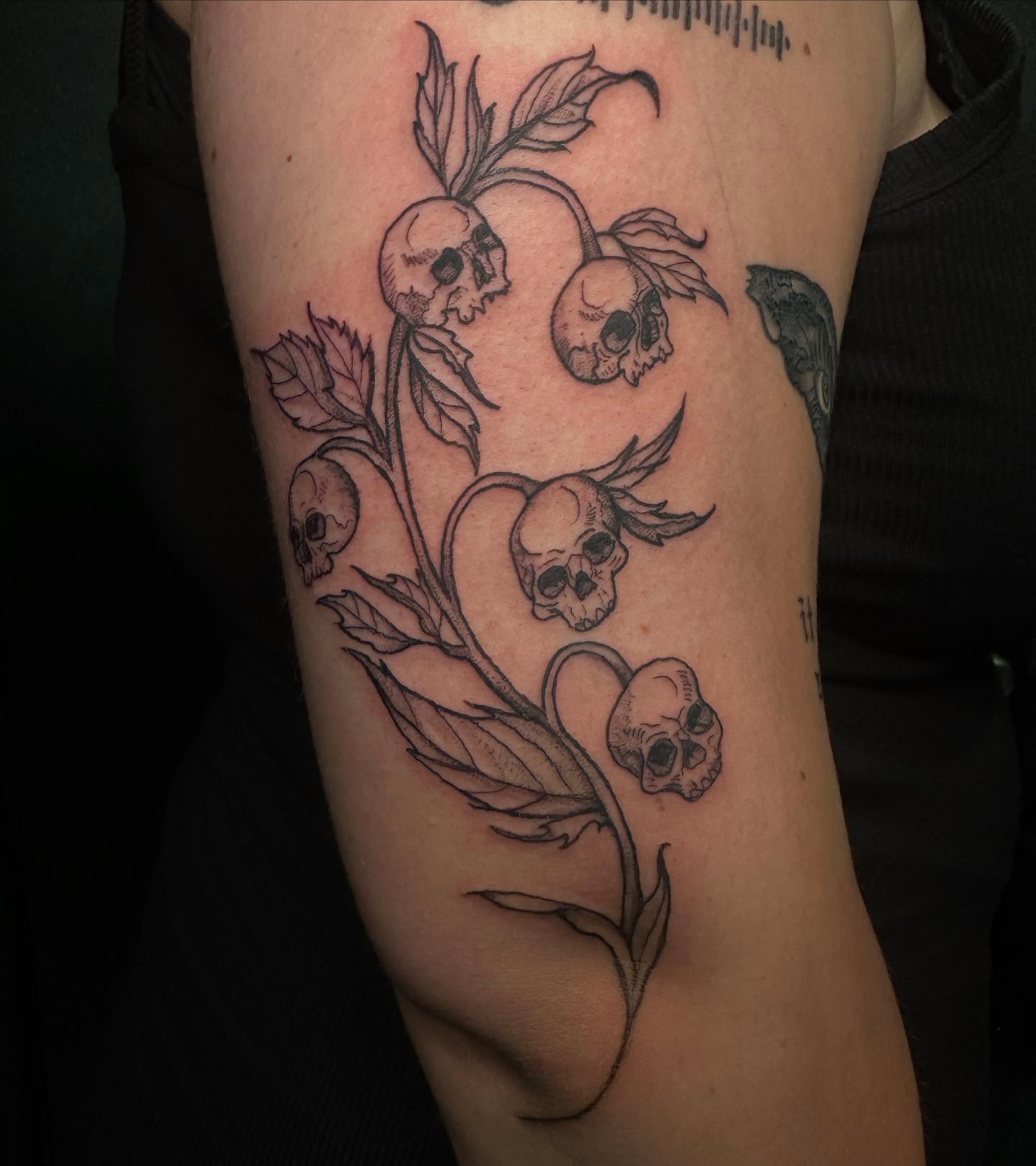 Skulls and leaves black and grey tattoo on the forearm by Mika'la Berry