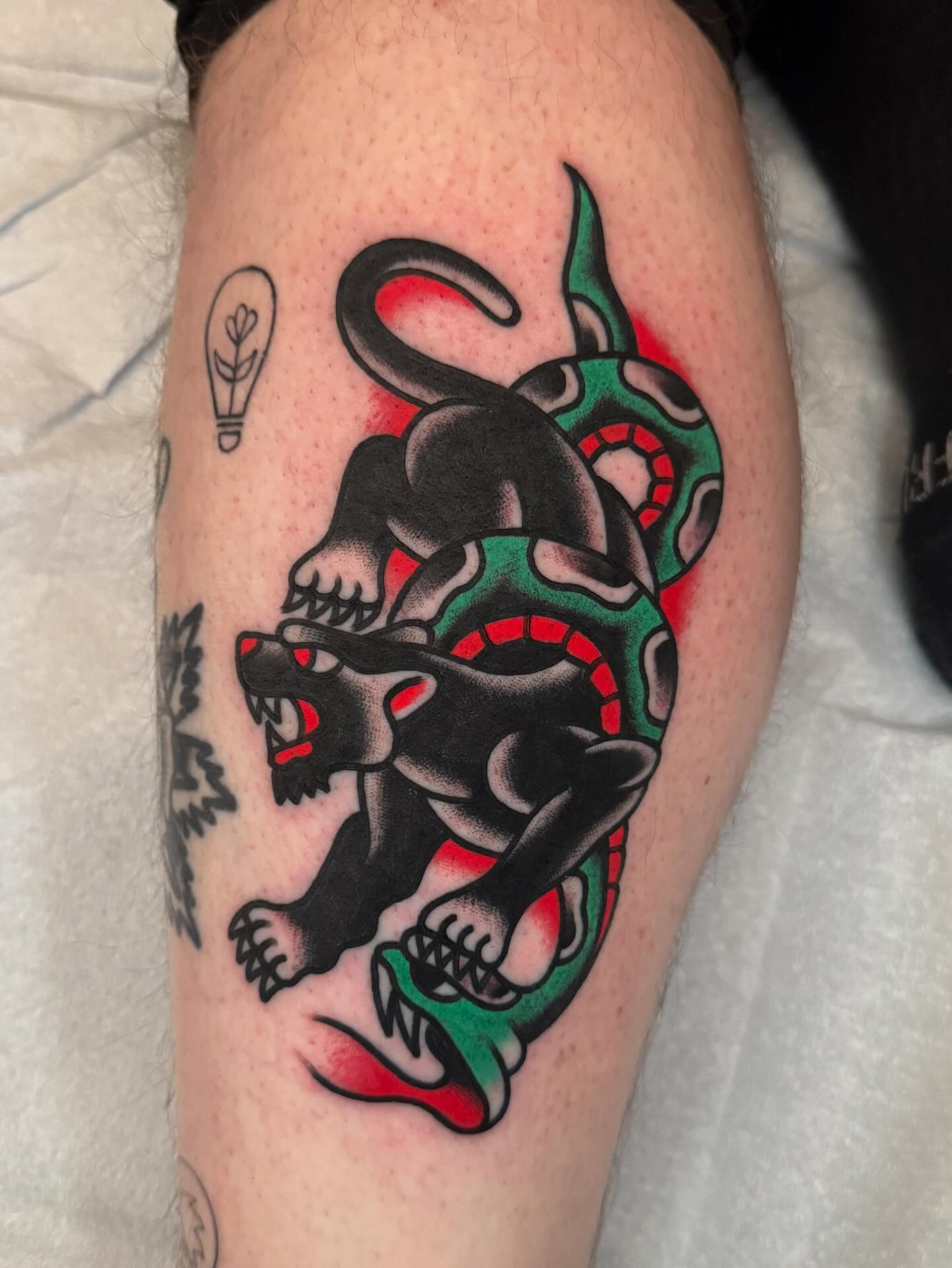 Panther and snake American traditional tattoo on the thigh by James Shepherd, Austin, Texas