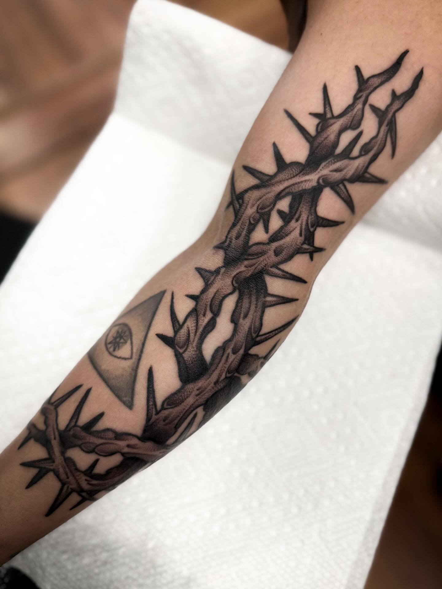 Crown of thorns black and grey tattoo on the forearm by Sam Babcock