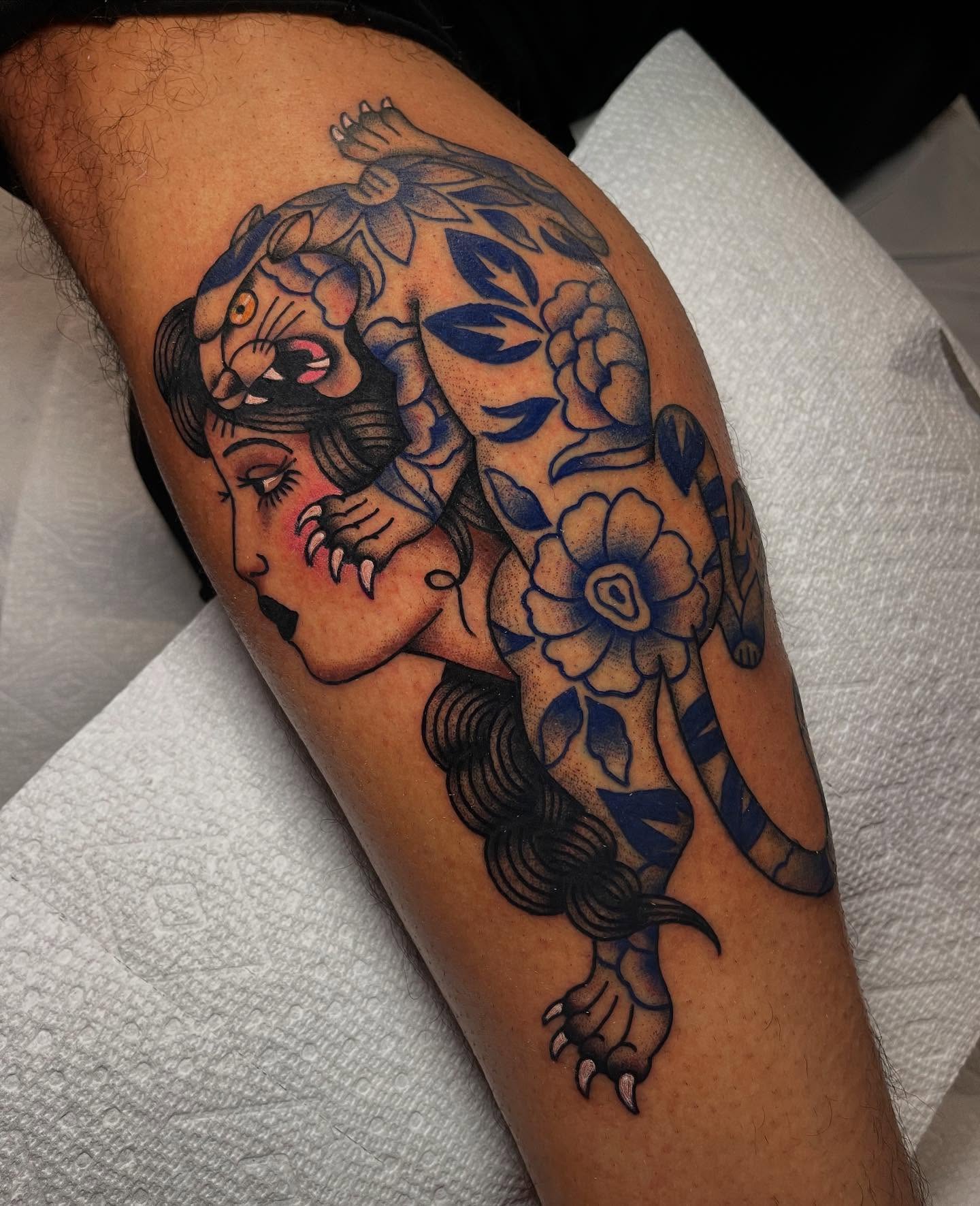 Woman and tiger American traditional tattoo on the thigh by Marqui Watling