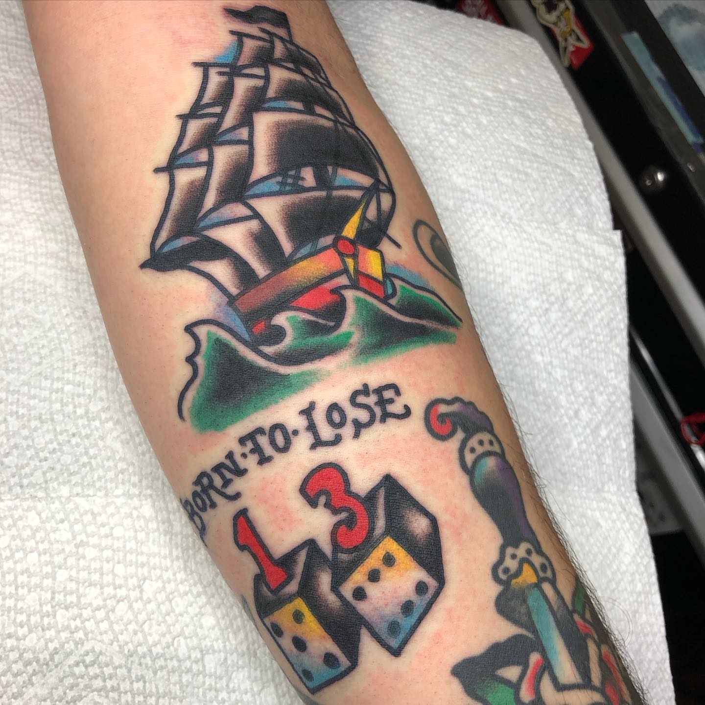 Ship and dice American traditional tattoo on the forearm by Tattoo