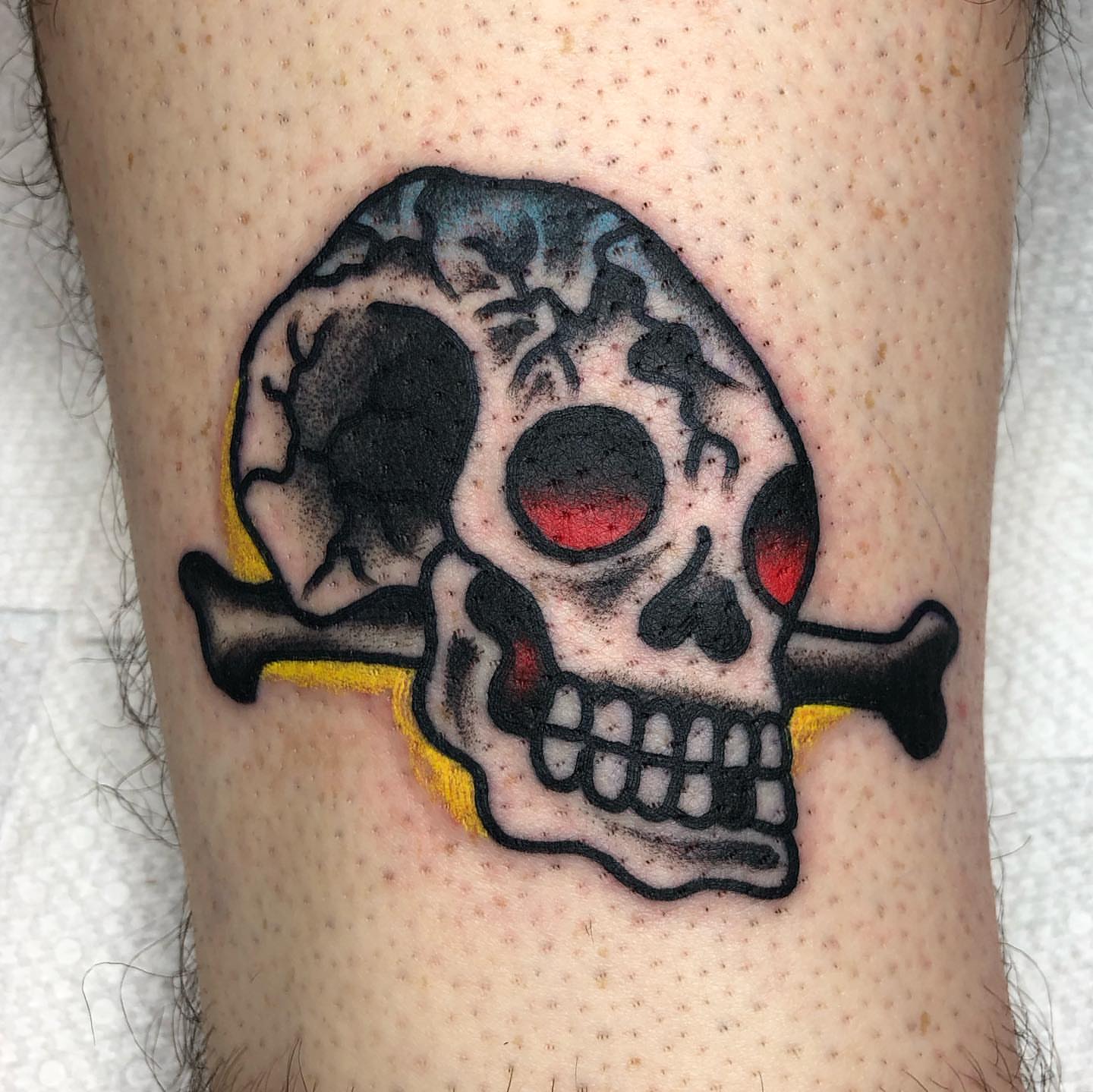 Skull and crossbones American traditional tattoo on the forearm by Tattoo