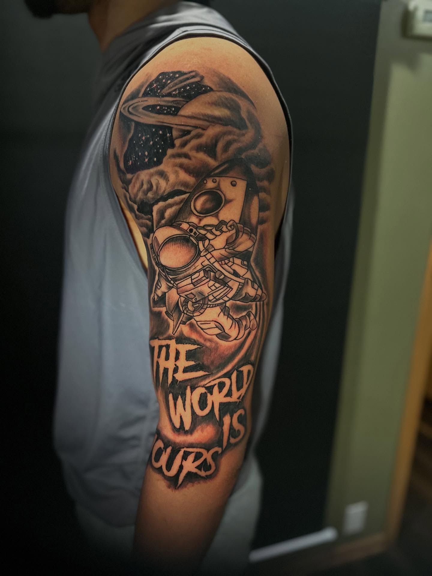 Astronaut and planet realism tattoo on the upper arm by George Zabala, Rockdale, Illinois
