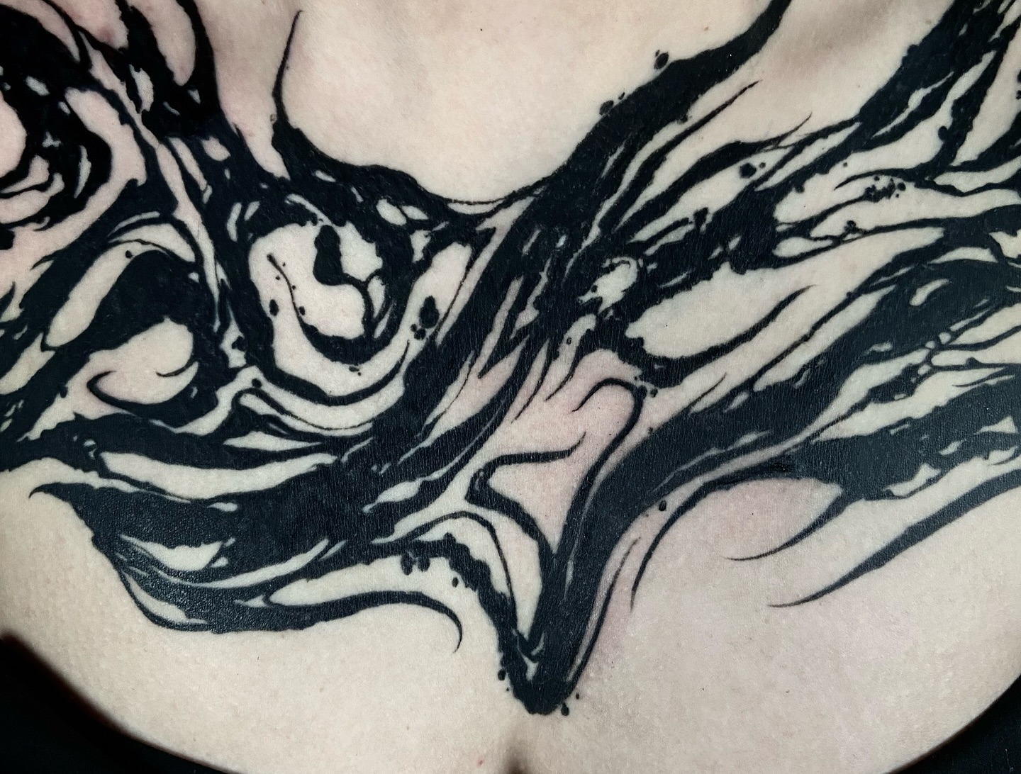 Abstract swirls black and grey tattoo on the chest by Nathan