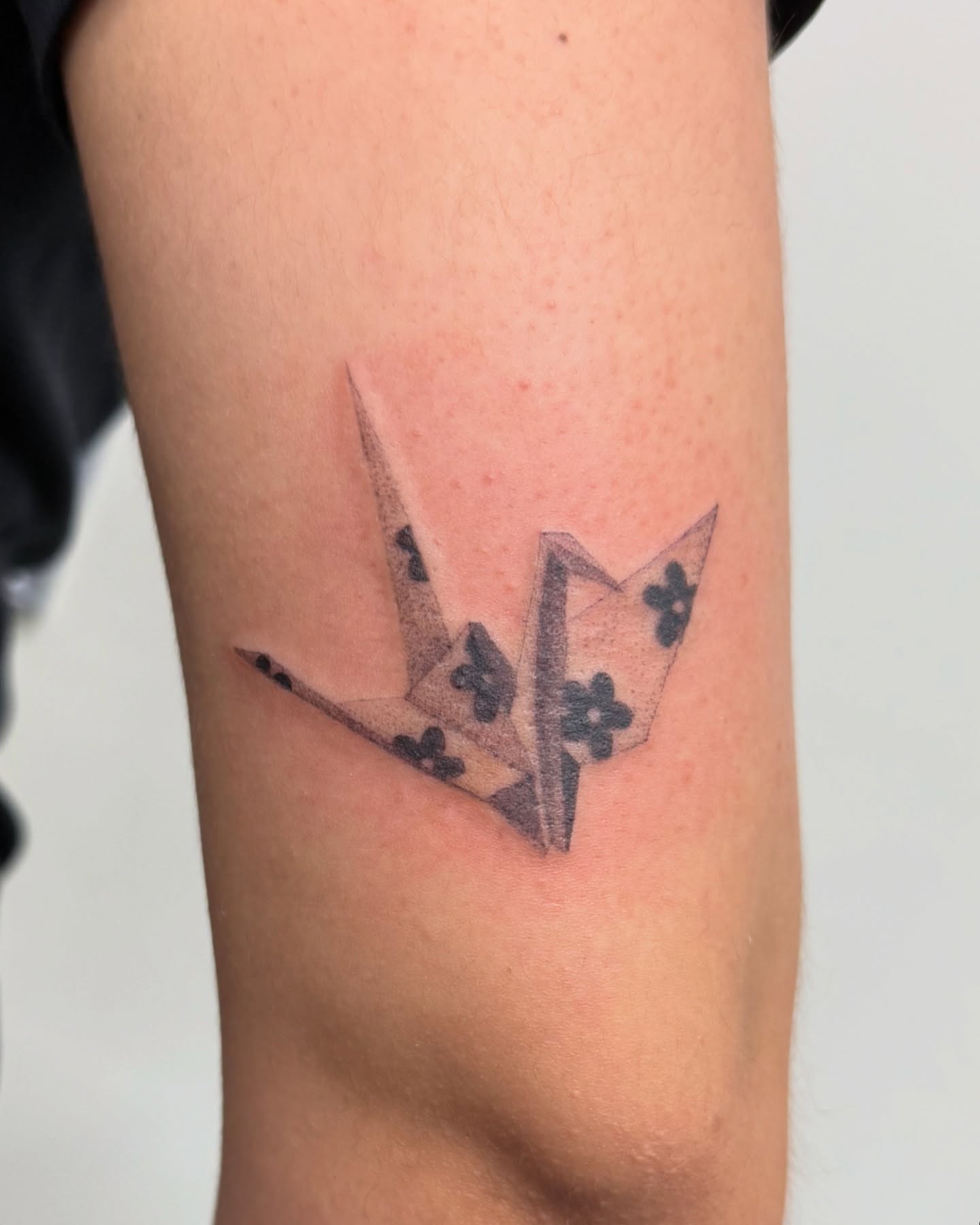 Origami crane black and grey tattoo on the forearm by liliana lopez