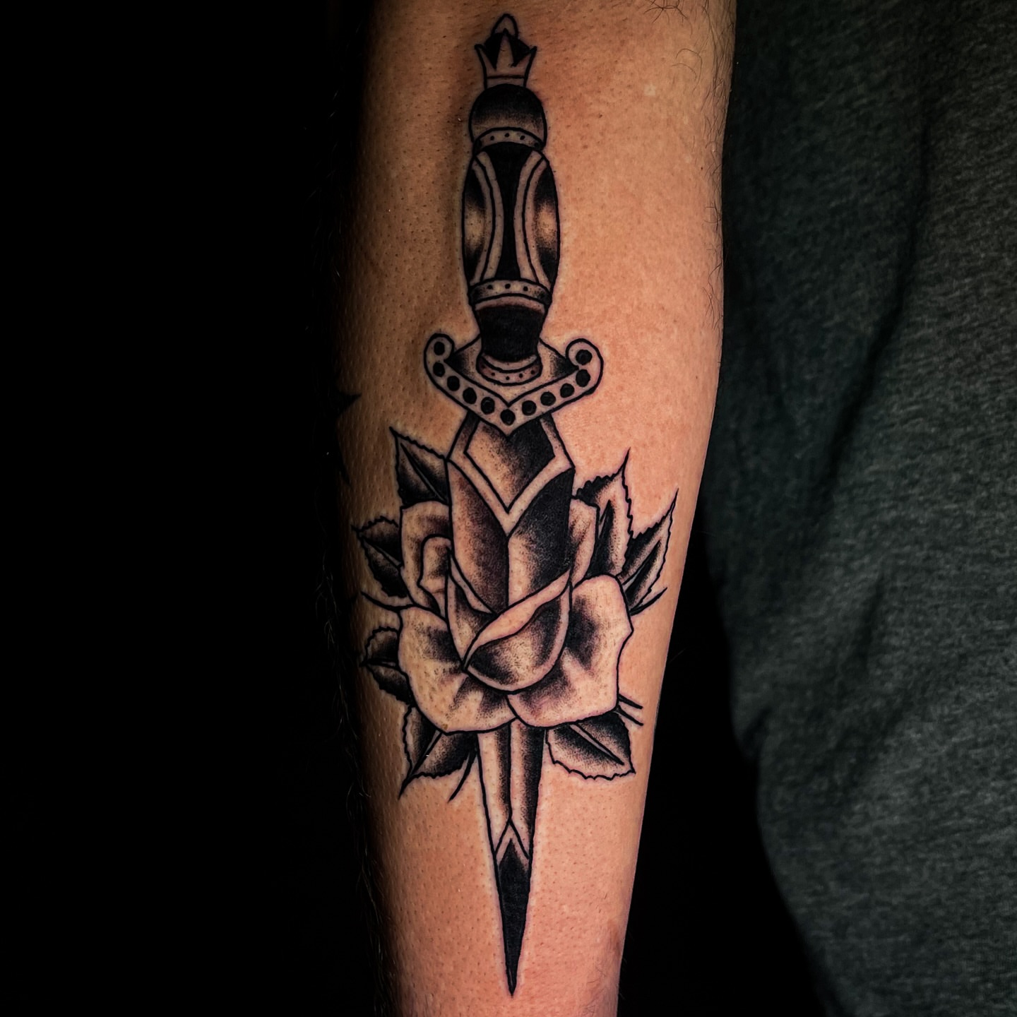 Sword and rose black and grey tattoo on the forearm by Miguel Henrik