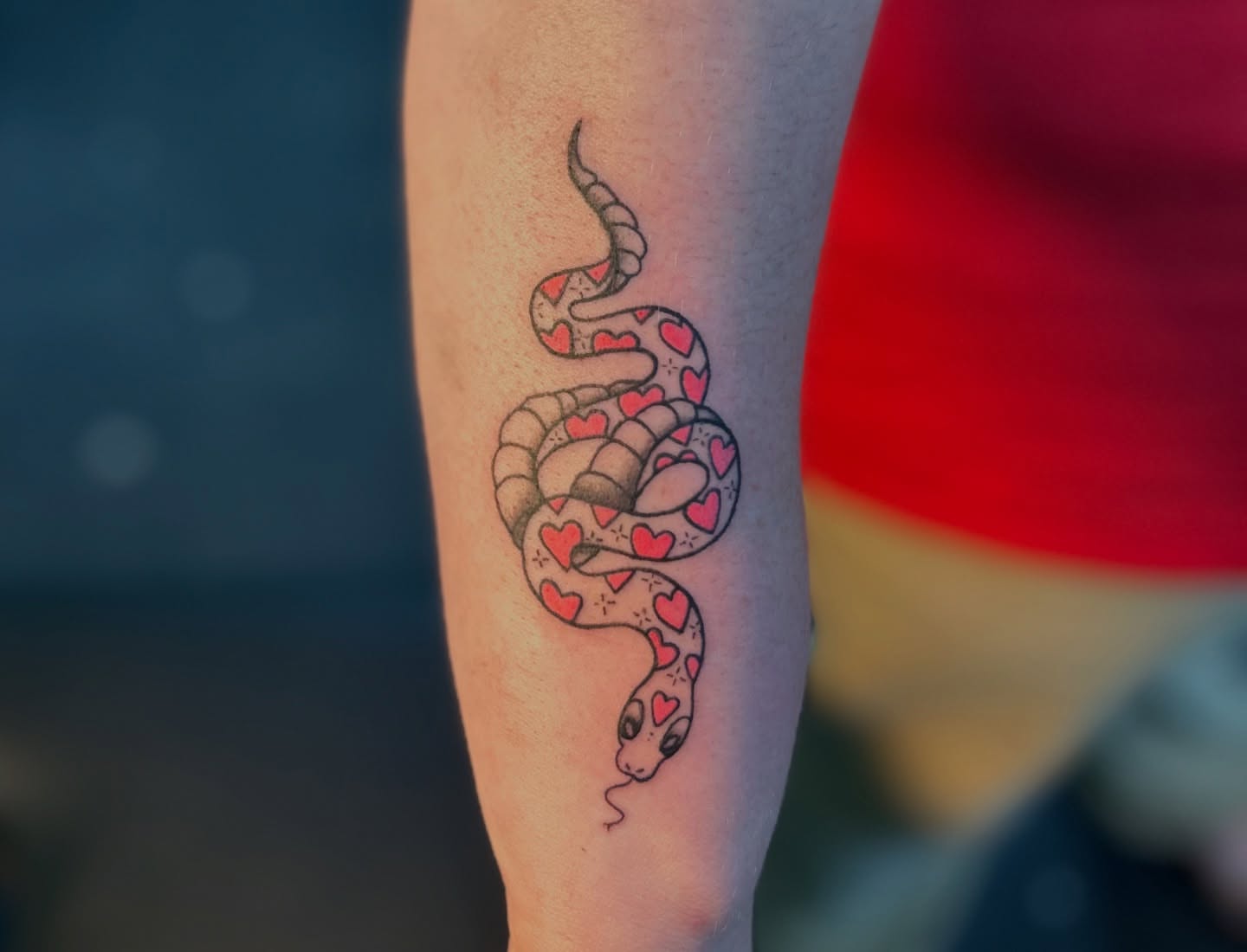 Snake with hearts dotwork tattoo on the forearm by Kiersten Tickle