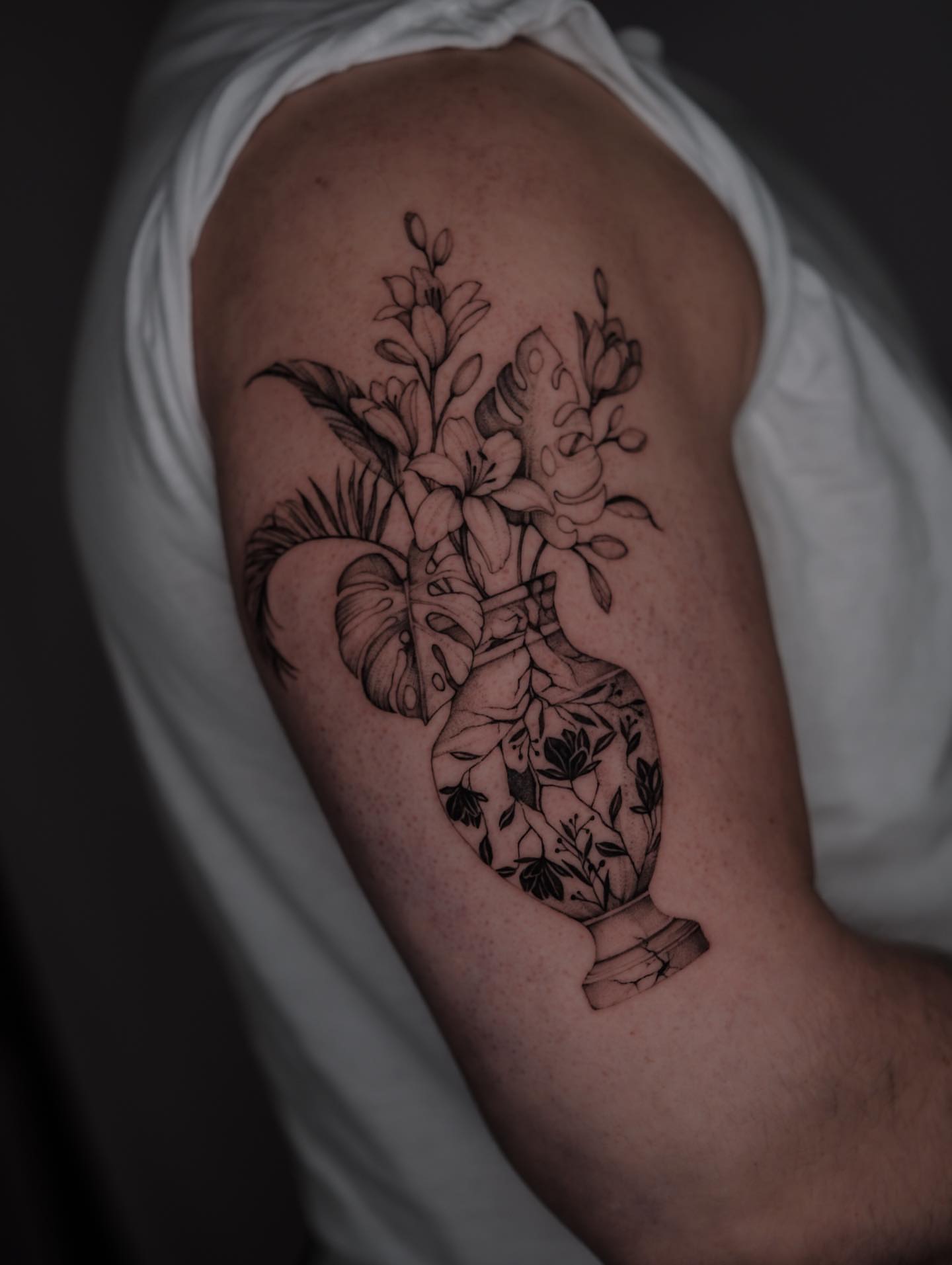 Heart with flowers black and grey tattoo on the upper arm by Tattoo artist in Boston