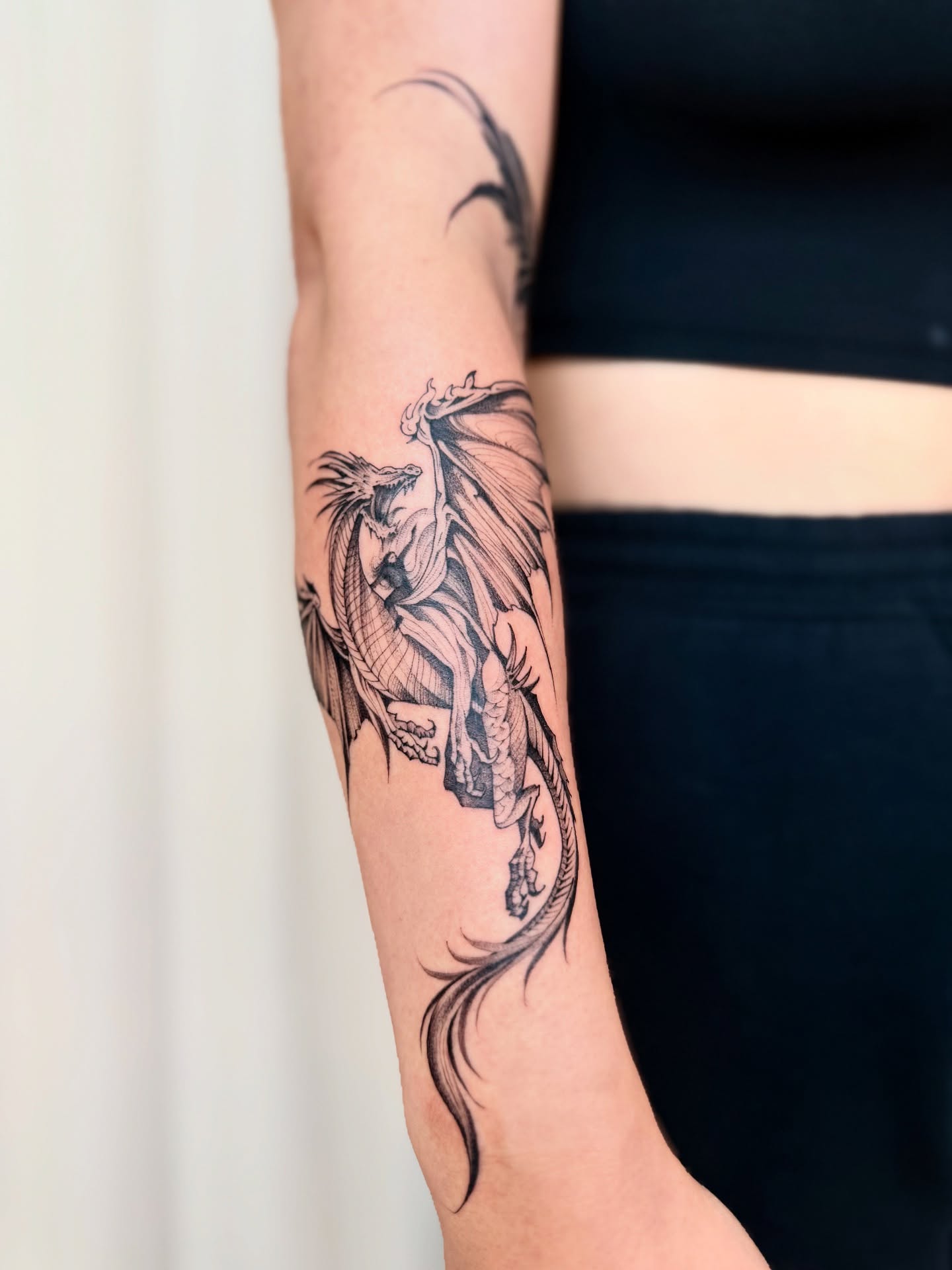 Dragon black and grey tattoo on the forearm by Dung Ngo