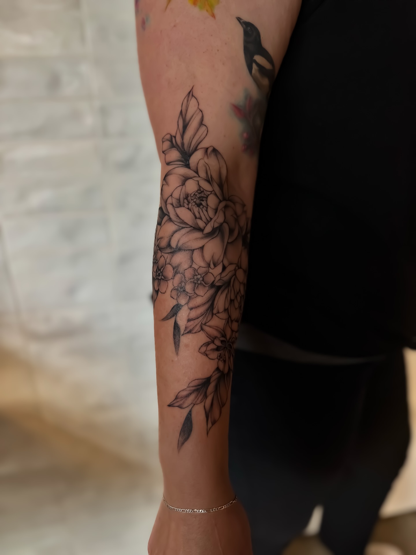 Floral arrangement black and grey tattoo on the forearm by Amelia