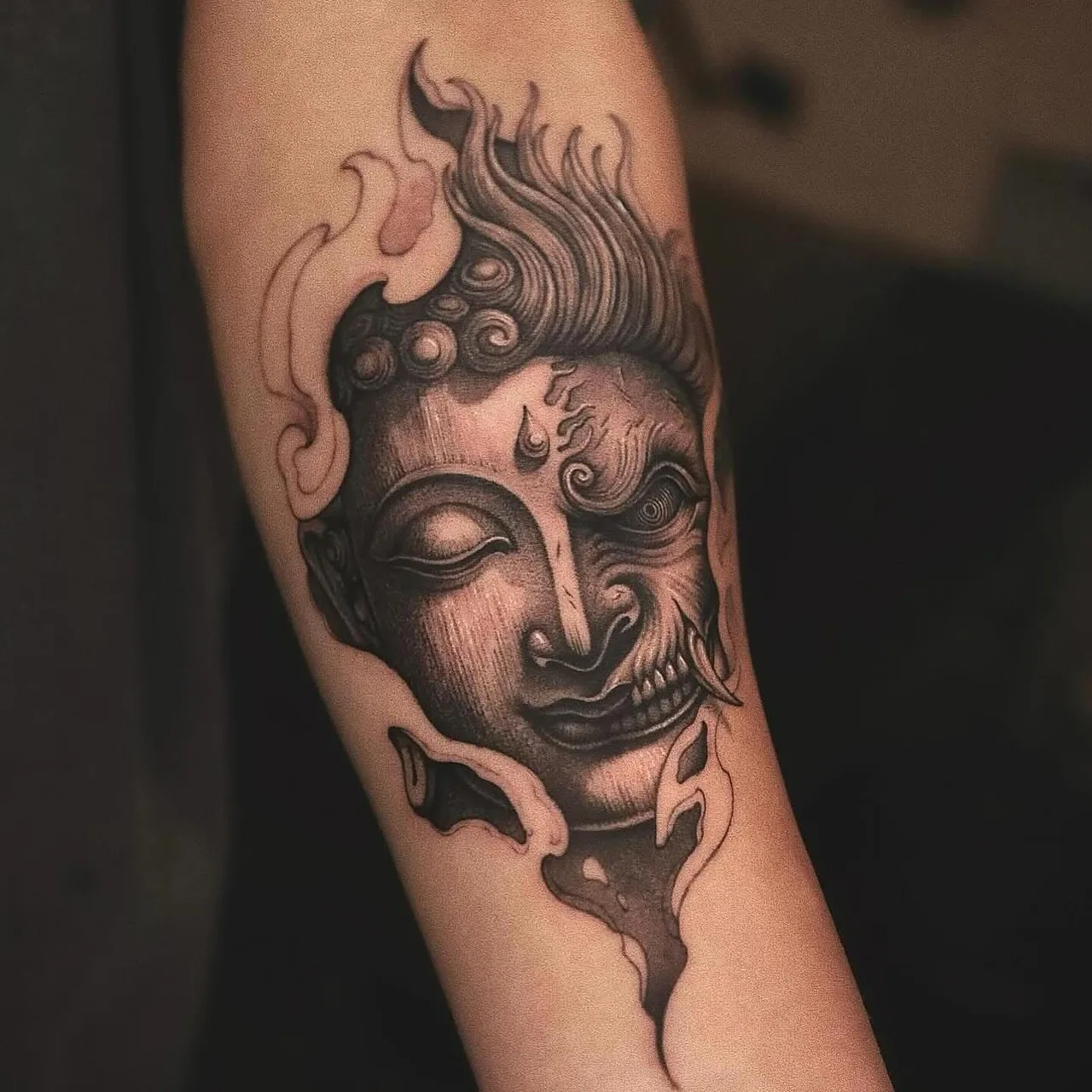Flaming Buddha head realism tattoo on the forearm by Minho