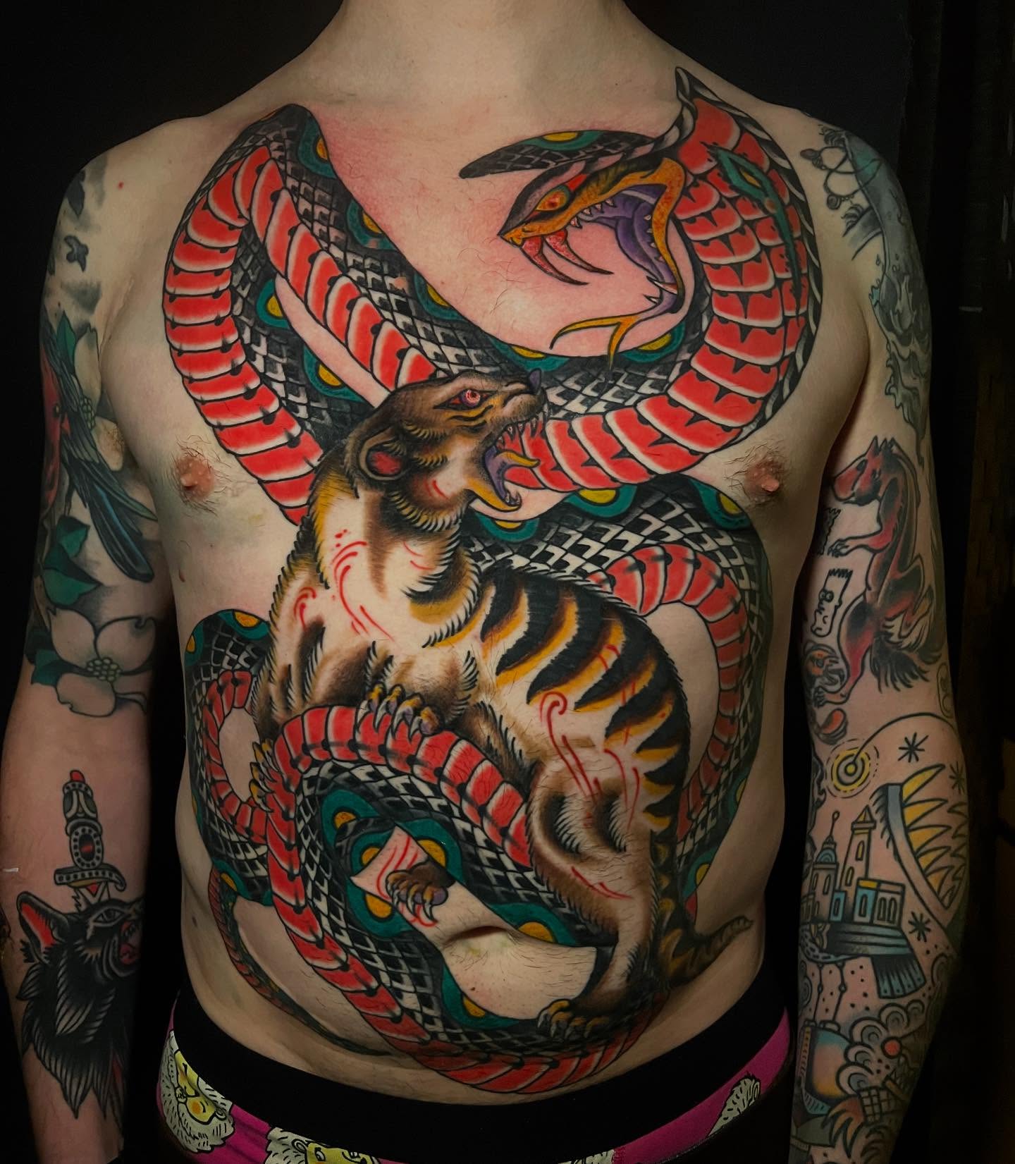 Tiger and snake American traditional tattoo on the chest by Matt E.