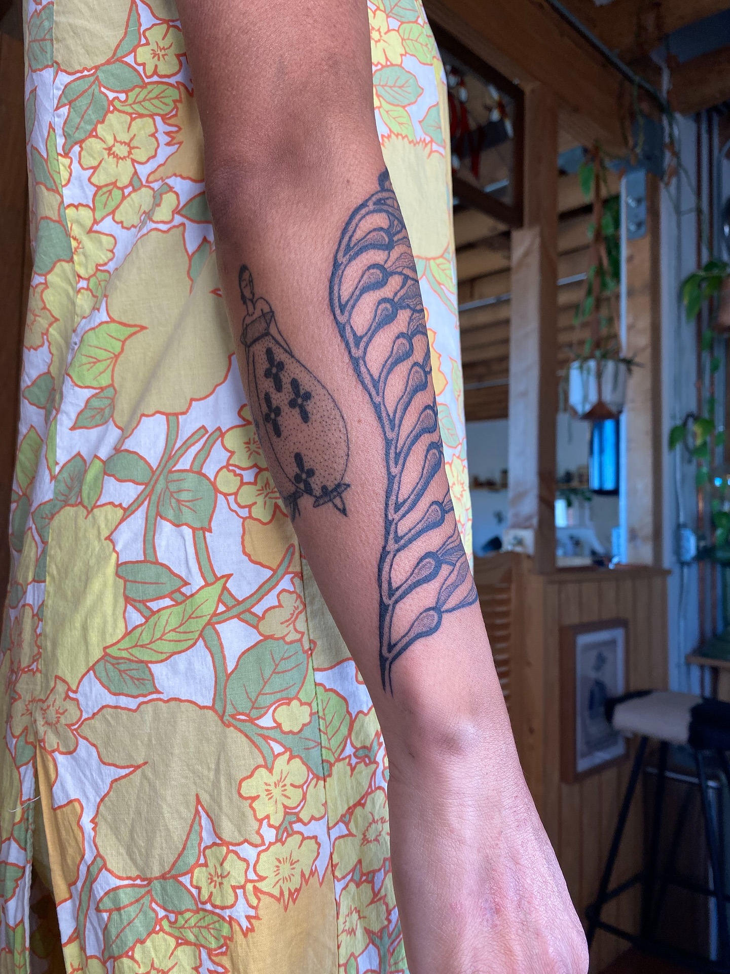 Bird and floral pattern black and grey tattoo on the forearm by Avery Kane