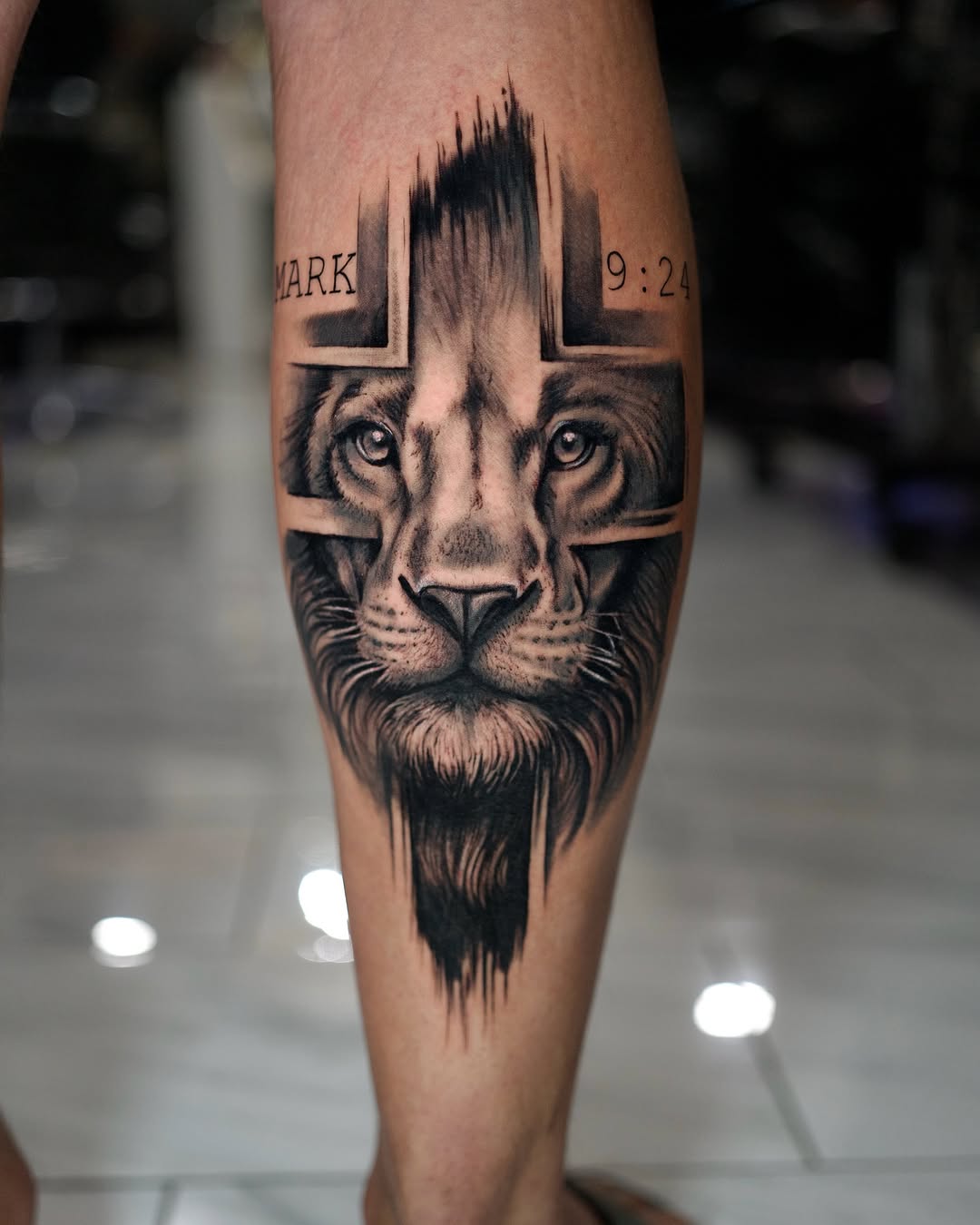 Lion face on cross with scripture Chicano tattoo on the forearm by Charlotte Tattoo Artist