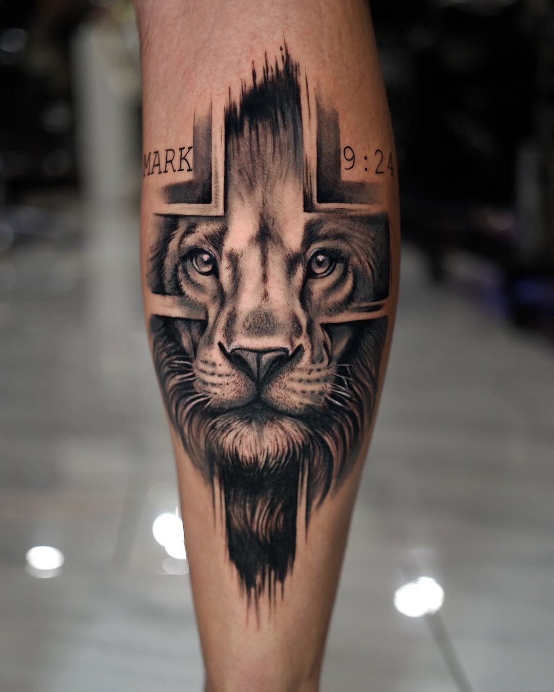 Lion face with cross Chicano tattoo on the forearm by Charlotte Tattoo Artist