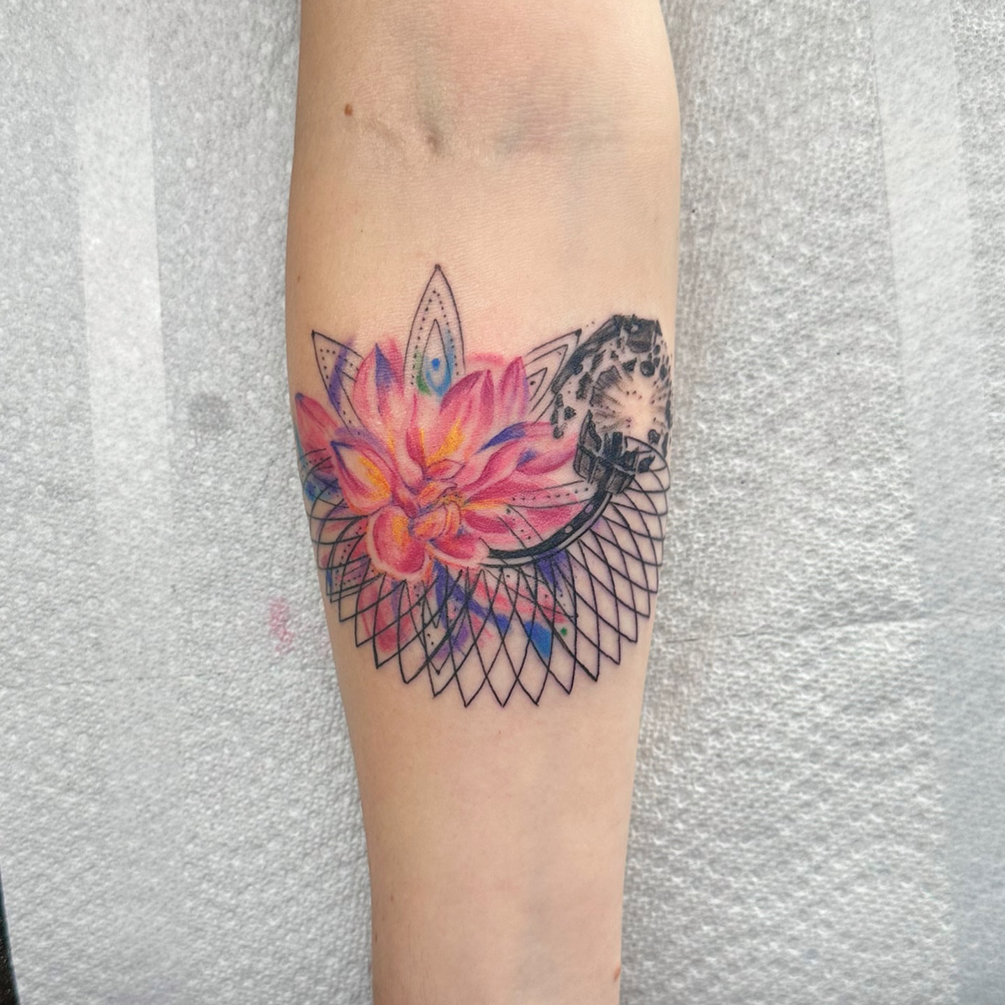 Lotus flower watercolor tattoo on the forearm by Jinx Ryder