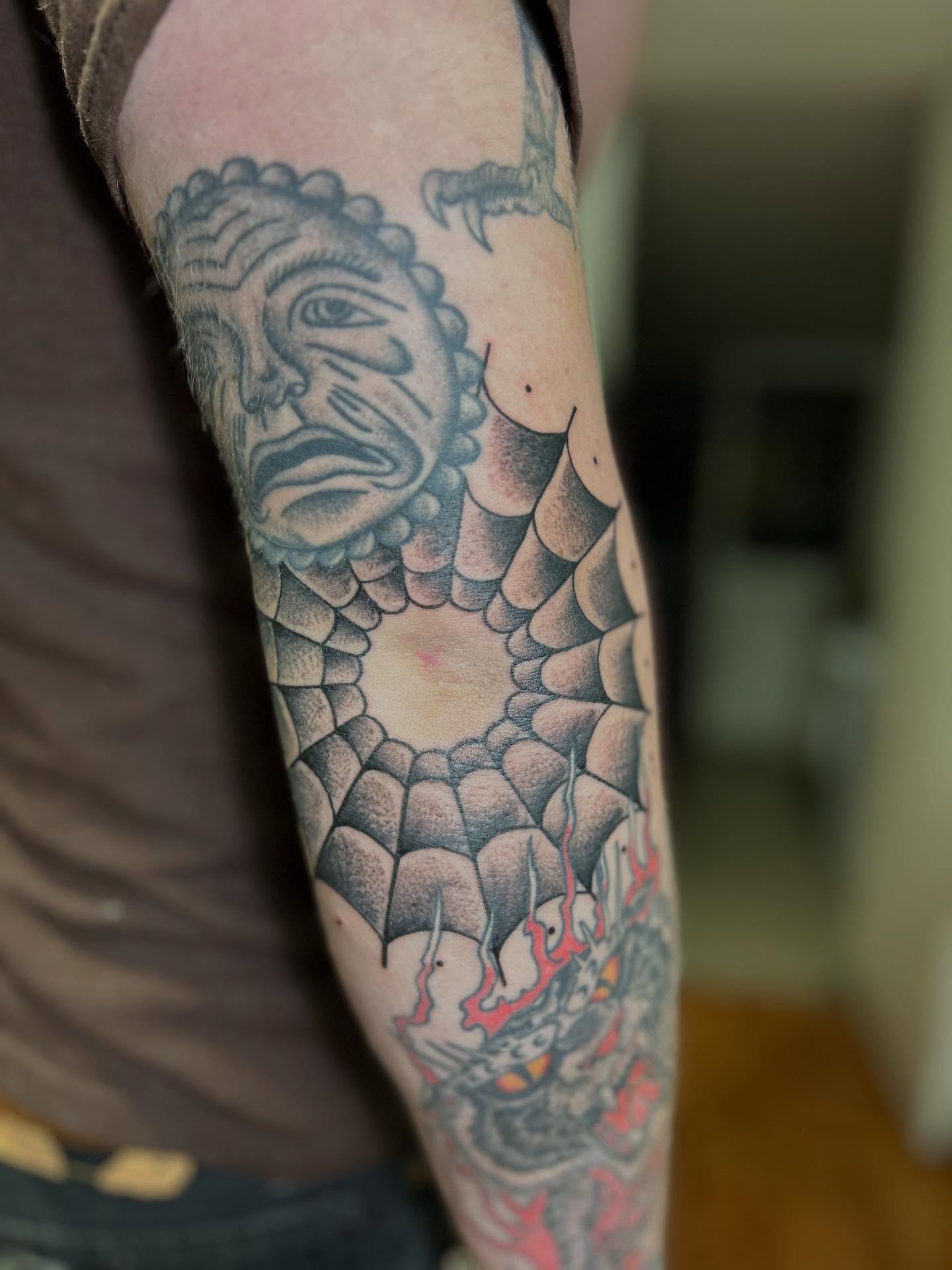Serpent and face American traditional tattoo on the forearm by Barro