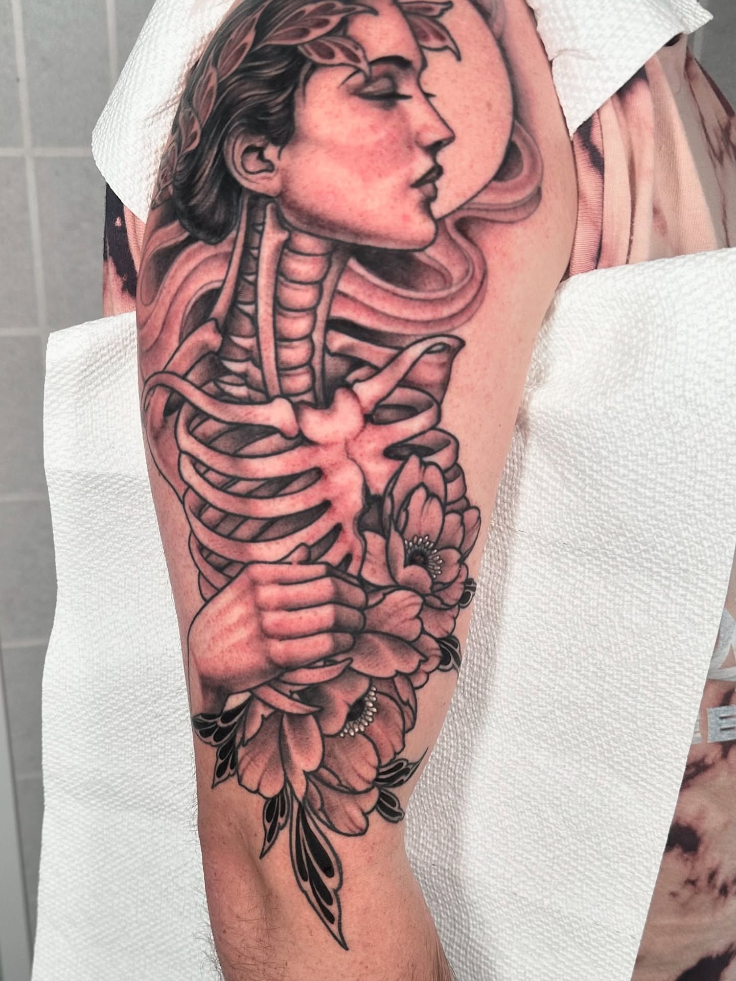 Female figure with flowers realism tattoo on the forearm by Henry Gaßner