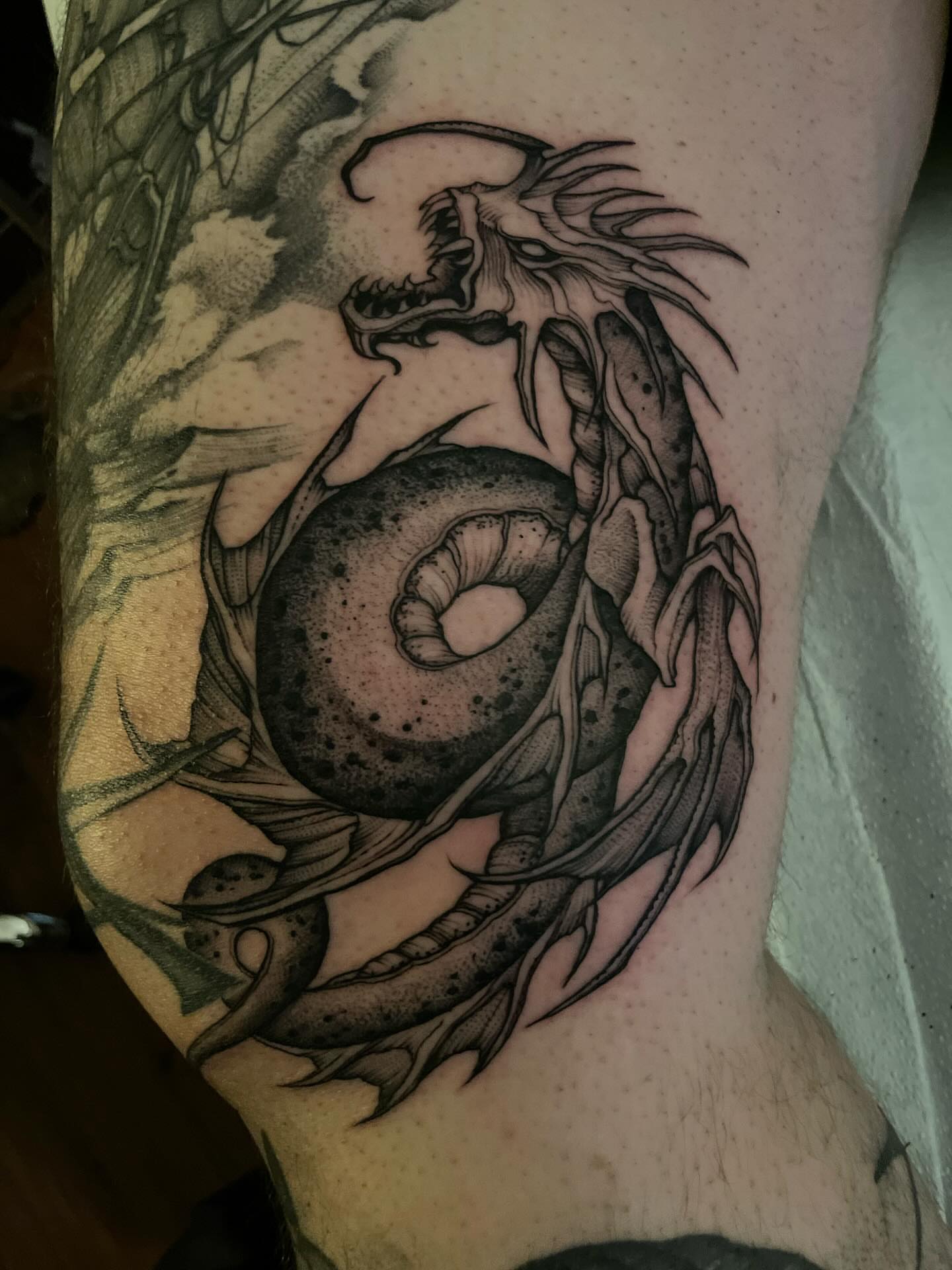Dragon and orb dotwork tattoo on the forearm by Jacob Kearney