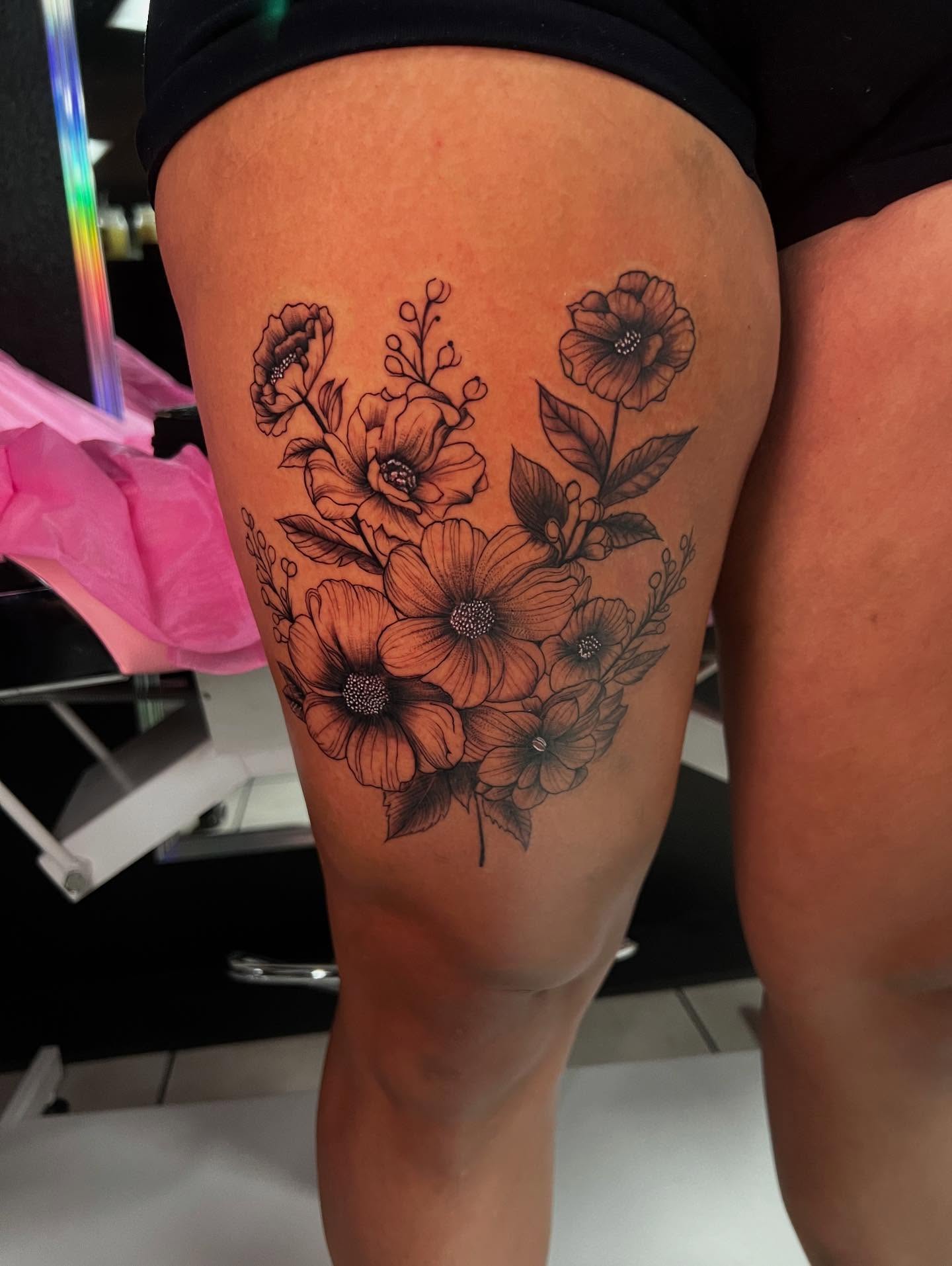 Floral bouquet black and grey tattoo on the thigh by Jasmin Lozano