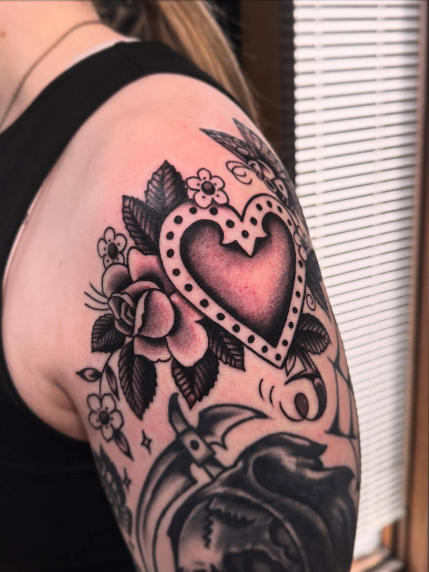Heart with floral elements American traditional tattoo on the shoulder by Ryan Engels