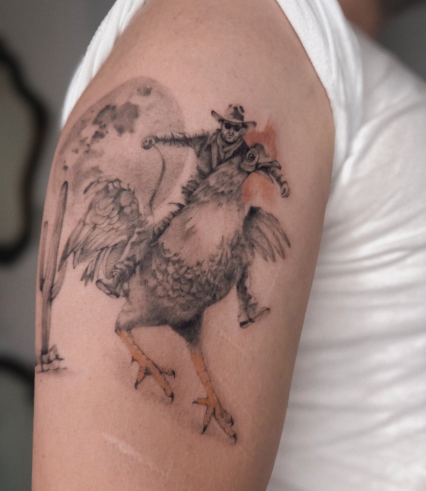 Cowboy riding bird realism tattoo on the upper arm by Blackwork & microrealism tattoos