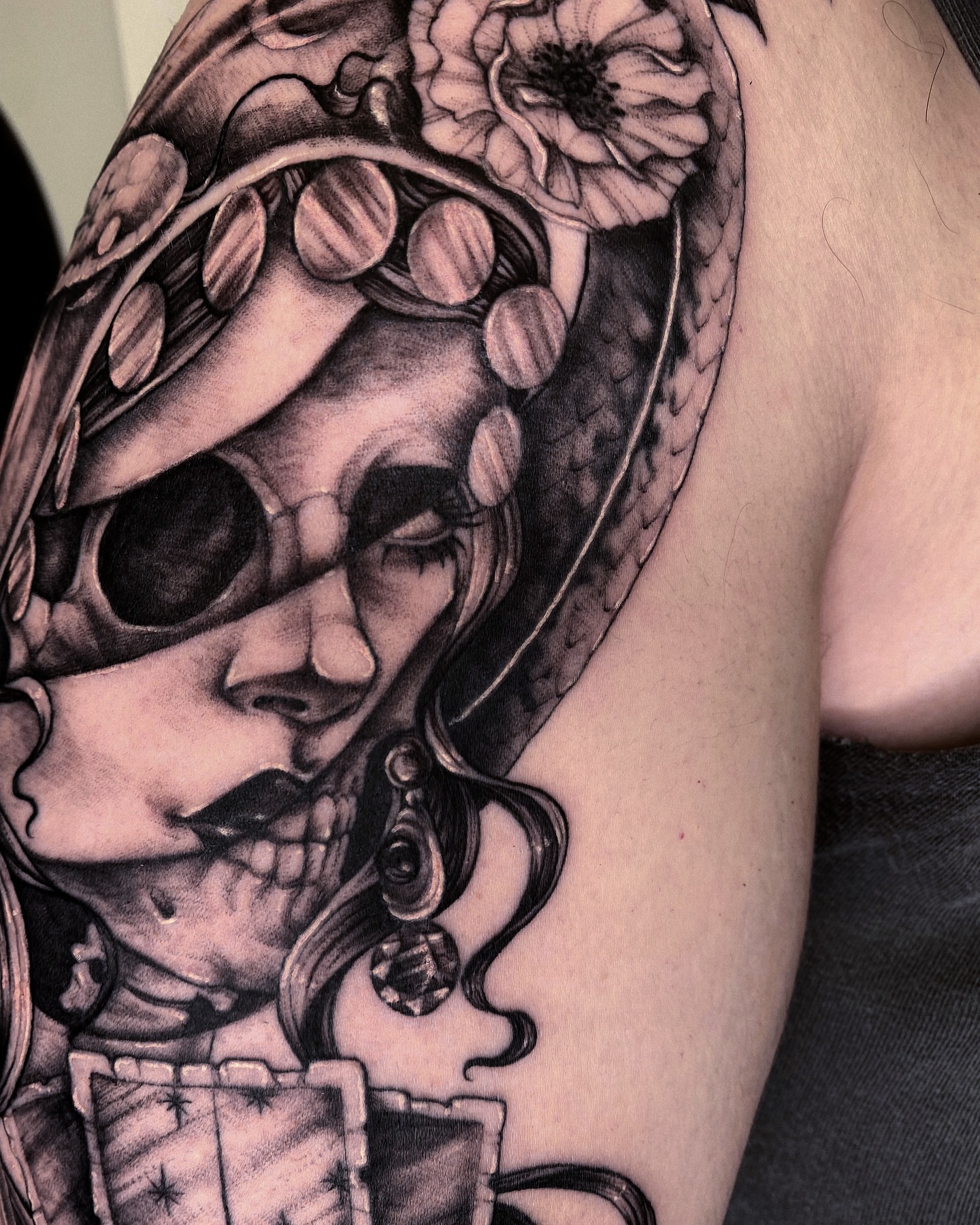 Skull with floral headdress realism tattoo on the shoulder by Jen Petronella