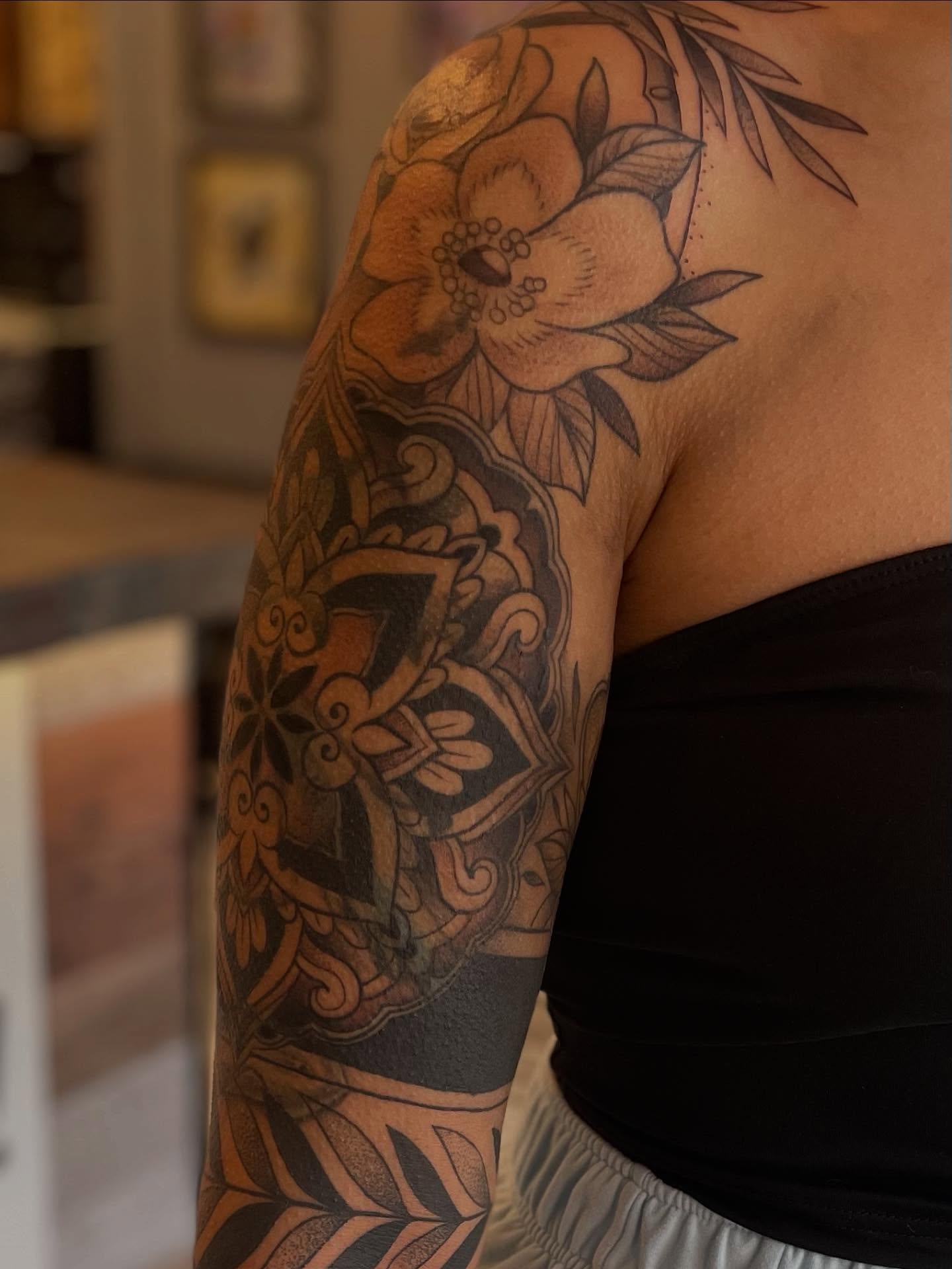 Floral and shield American traditional tattoo on the upper arm by Stevie Timmreck, Utica, Michigan
