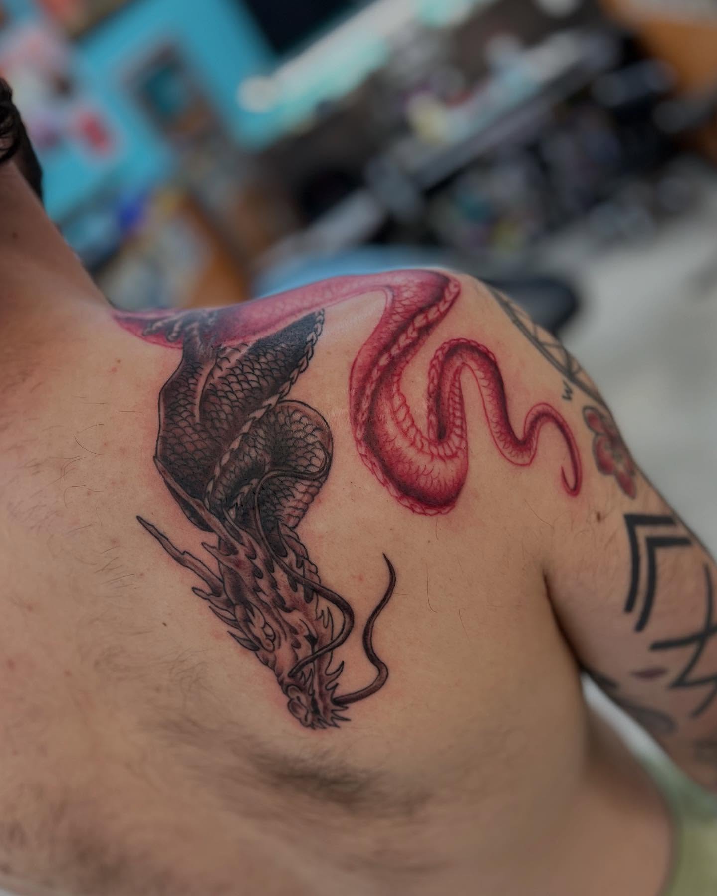 Dragon and snake American traditional tattoo on the shoulder by Levi Sawdon, Everett, Washington