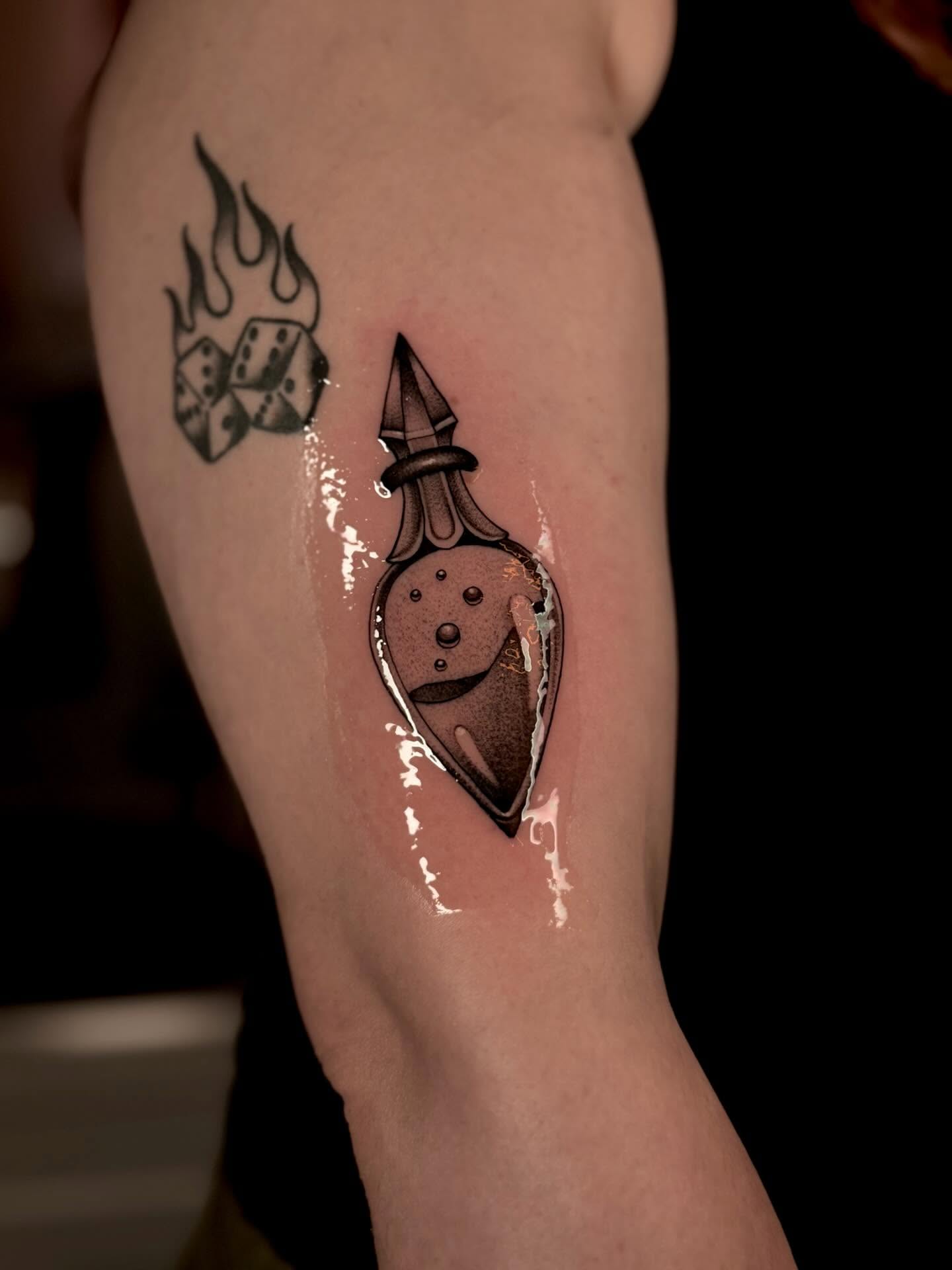 Vial with liquid dotwork tattoo on the forearm by laura baldwin