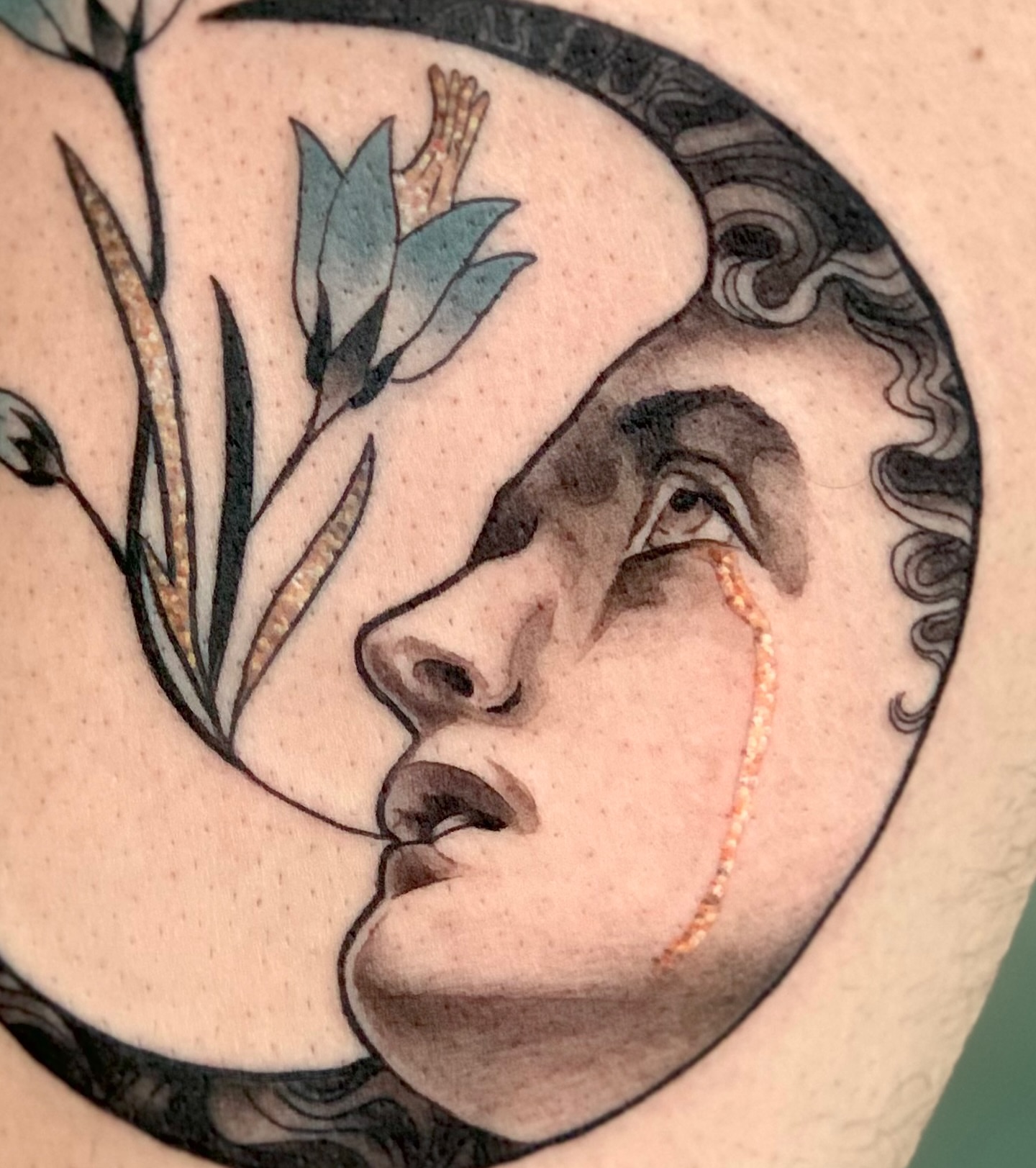 Woman's face with crescent moon realism tattoo on the chest by Laura Babsie