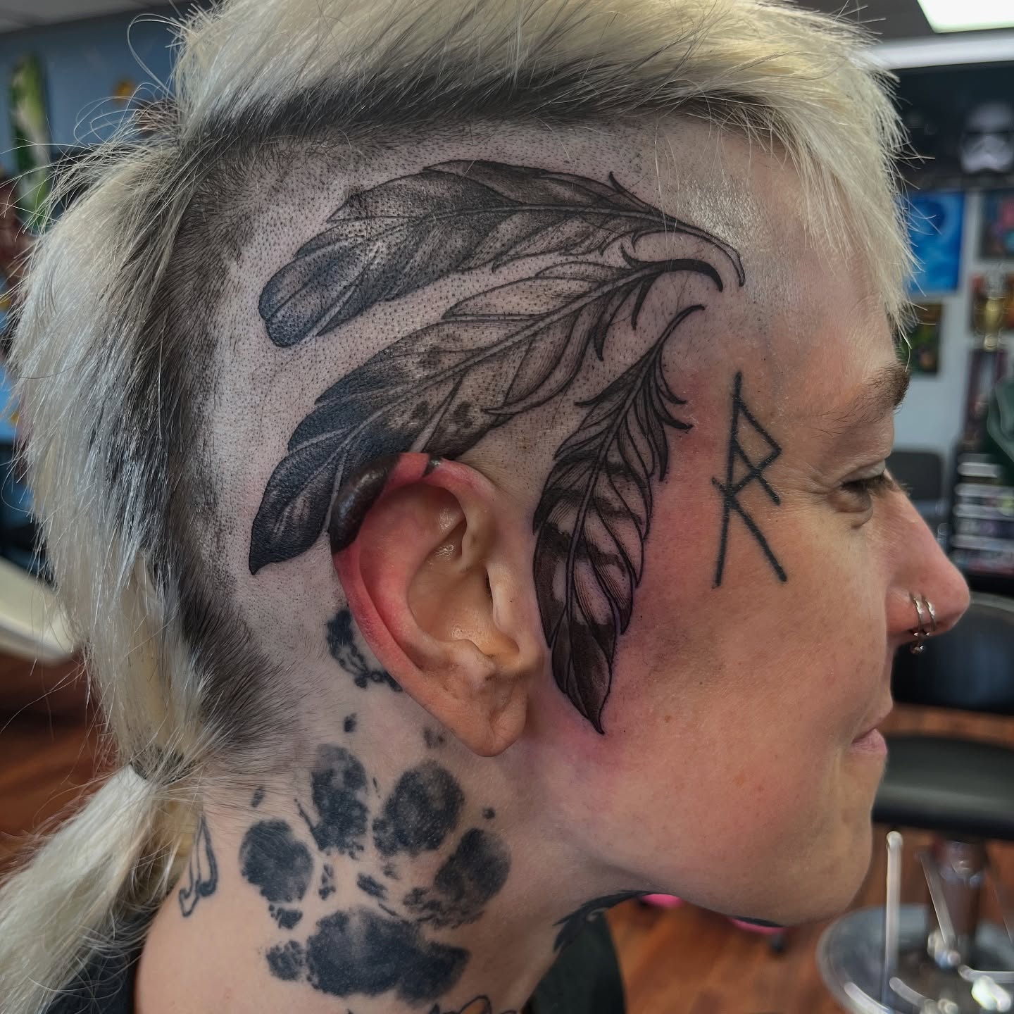 Feather dotwork tattoo on the head by Caito Conner