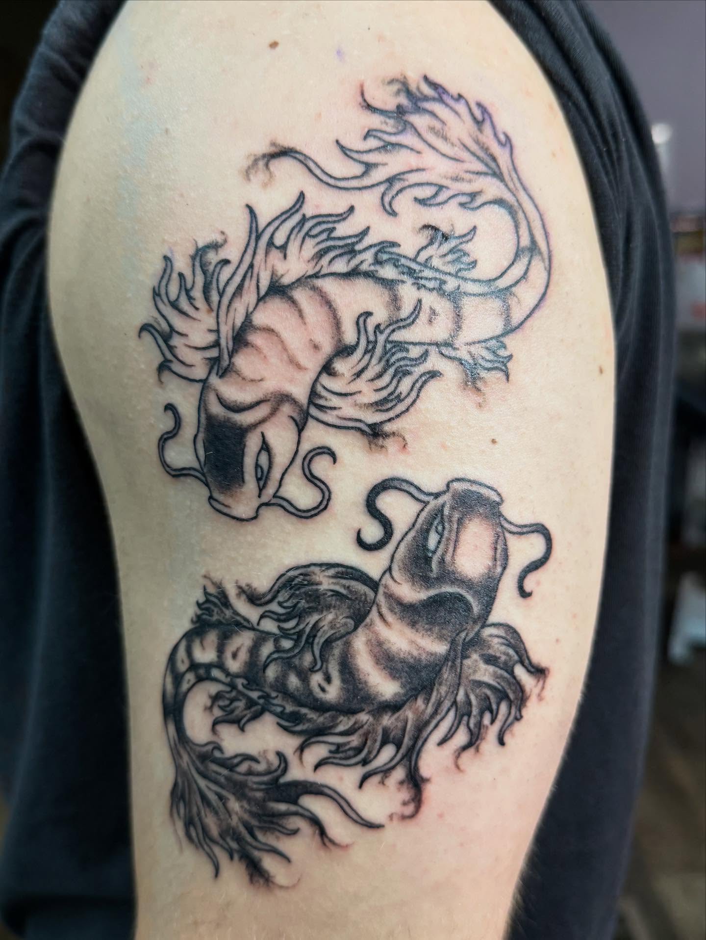 Dragons black and grey tattoo on the shoulder by Hunter Beyer