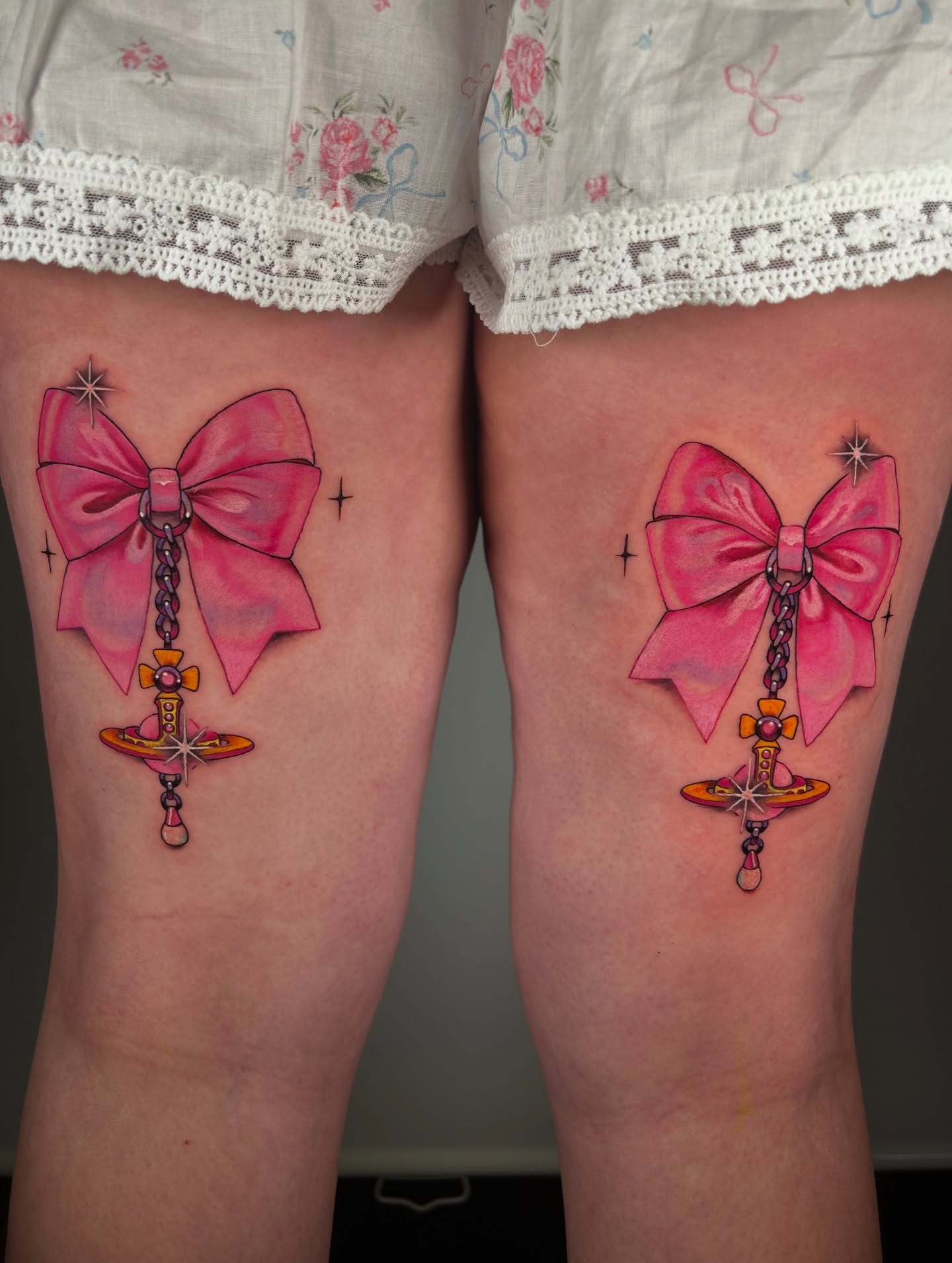 Pink bow with sword new school tattoo on the thigh by Chloe Marie