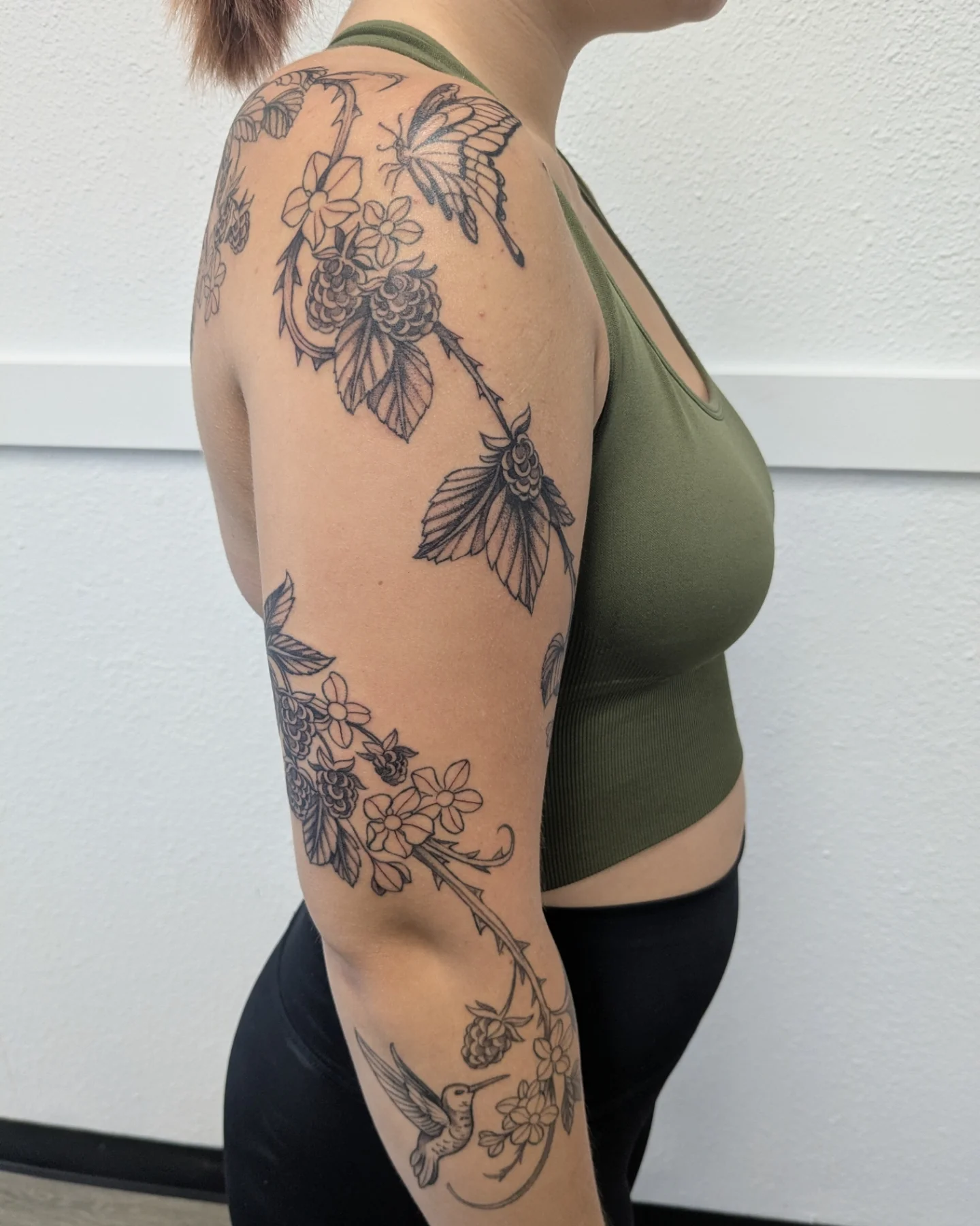 Floral and hummingbird black and grey tattoo on the upper arm by Ana Cielo Dueñas🌿Fernewt🌿Tattoo Artist🌿