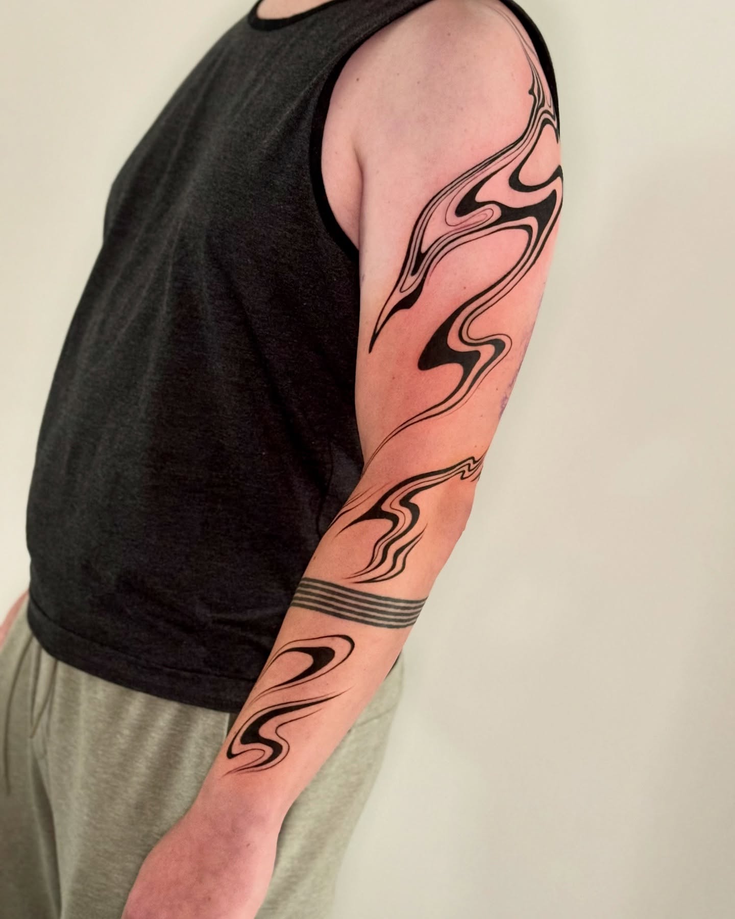 Abstract wave black and grey tattoo on the forearm by Erin Blaney
