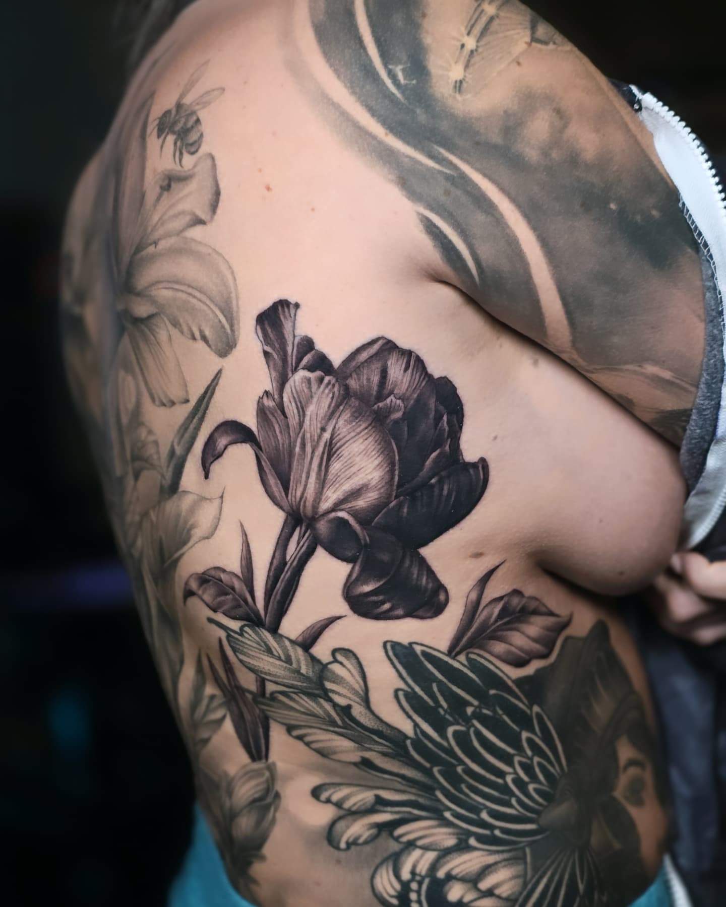 Tulip and leaves realism tattoo on the shoulder by Jake Barney