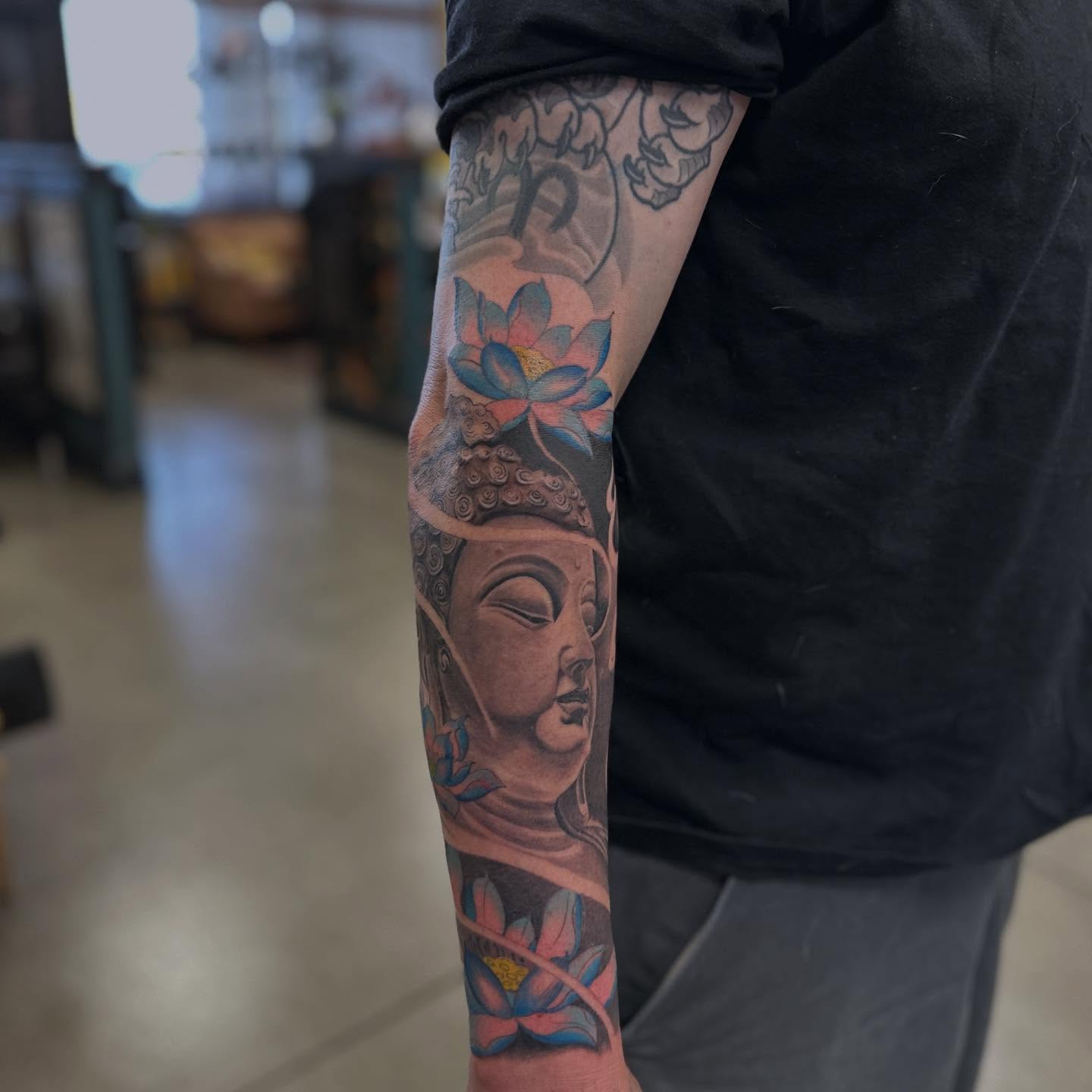 Buddha head with lotus American traditional tattoo on the forearm by Shawn Feng