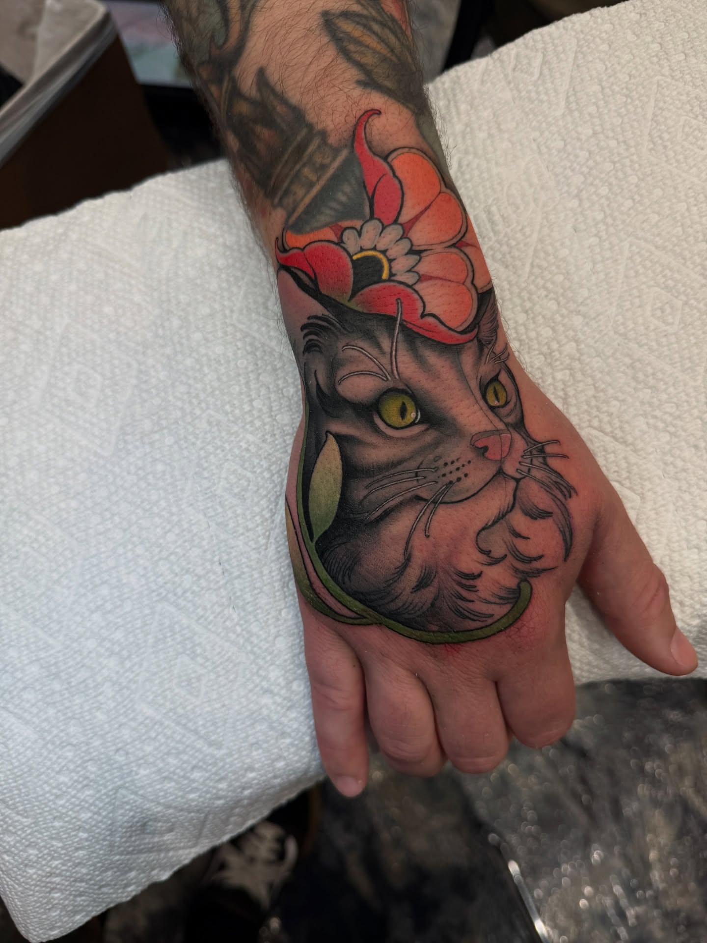 Cat with flower crown American traditional tattoo on the hand by Neotrav Tattoos