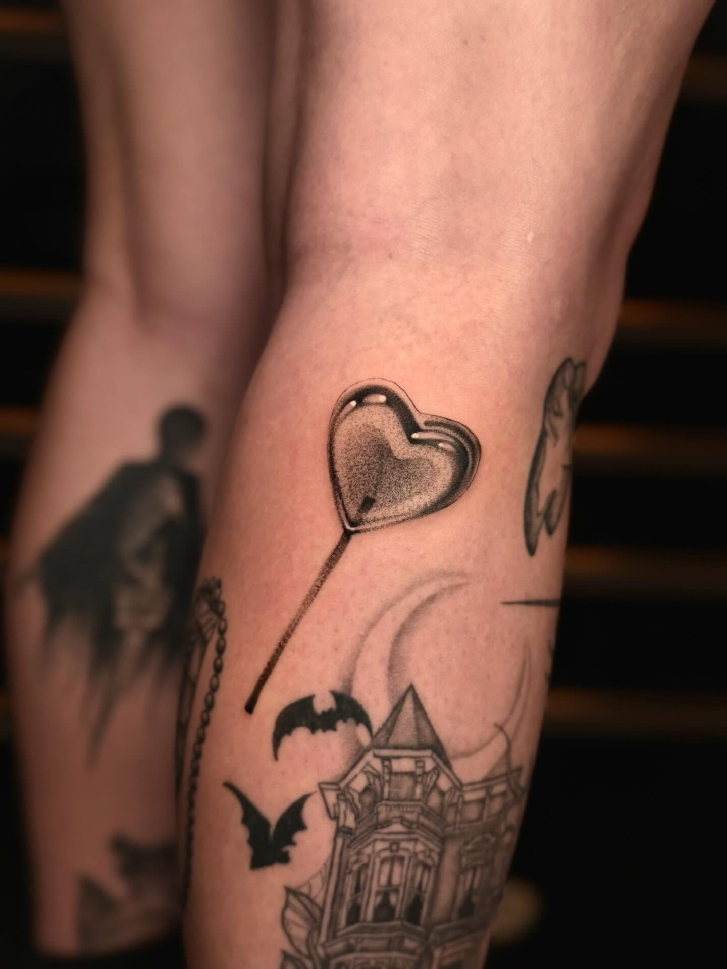 Heart-shaped lollipop dotwork tattoo on the forearm by laura baldwin