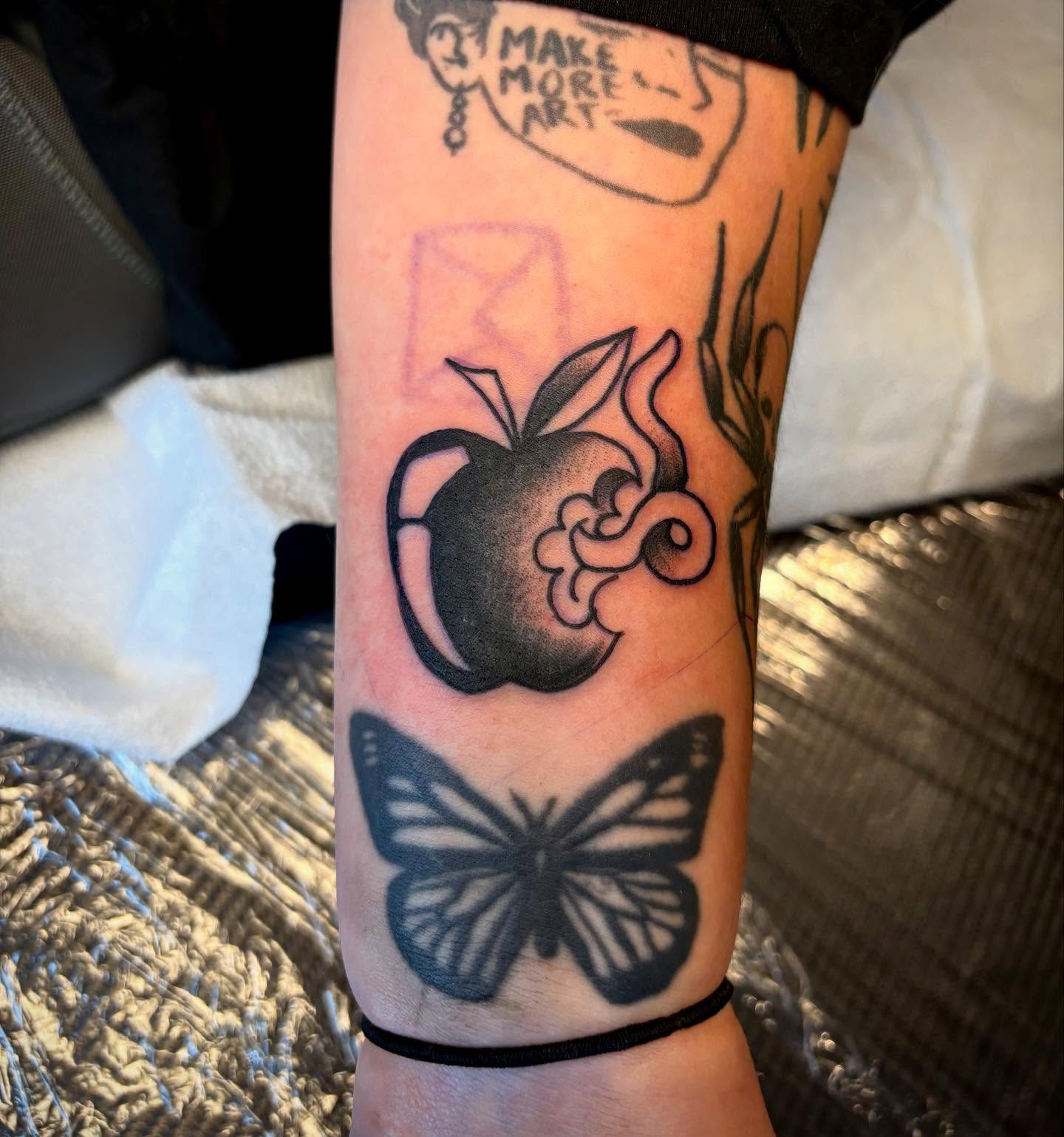 Smoking apple black and grey tattoo on the forearm by Nolan Croteau
