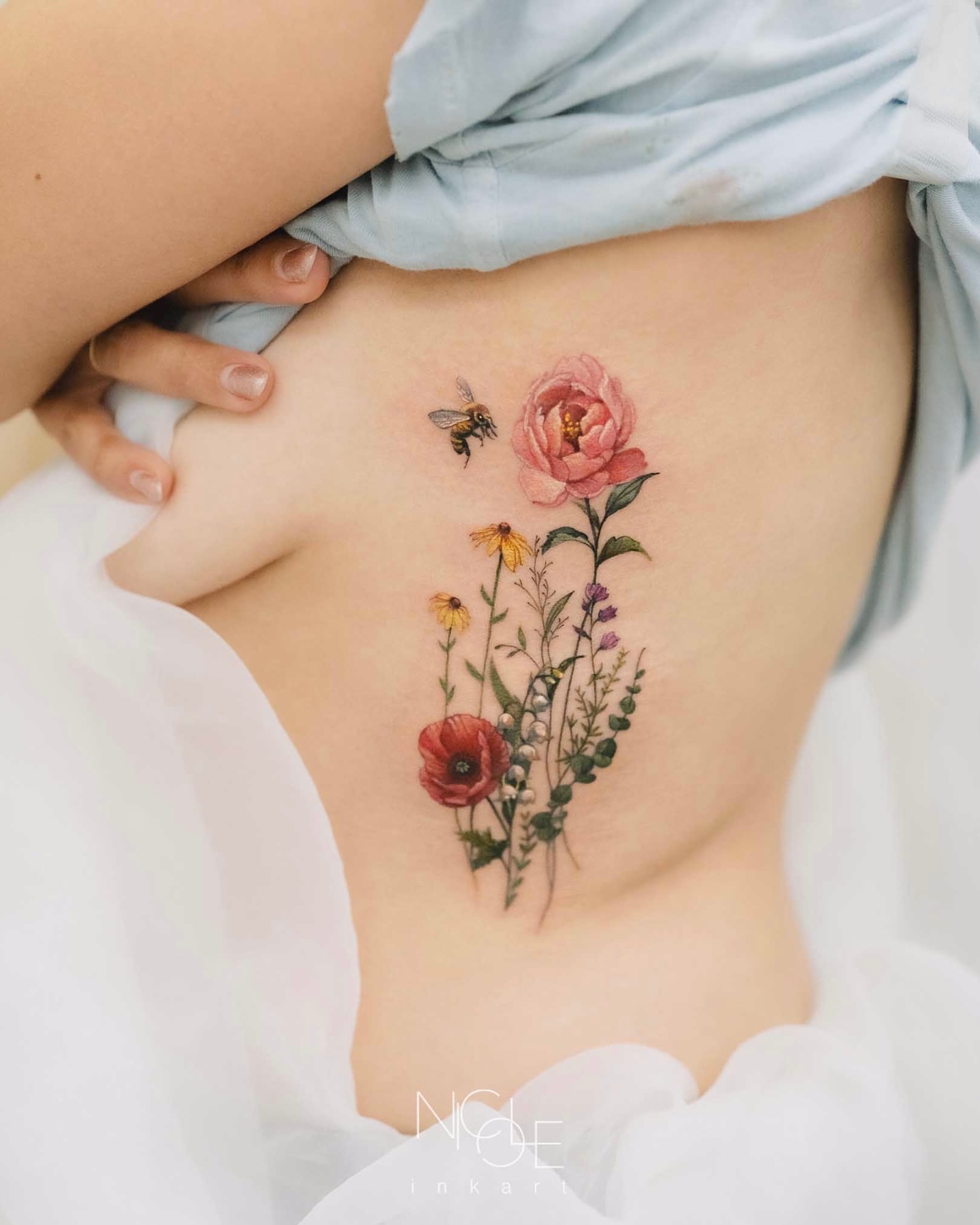 Floral arrangement watercolor tattoo on the ribs by 𝐍𝐈𝐂𝐎𝐋𝐄 𝐋