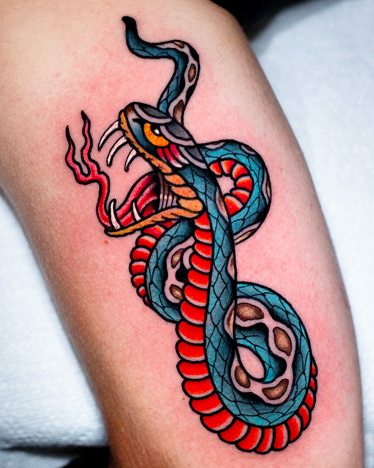 Snake American traditional tattoo on the thigh by Miguel Comin