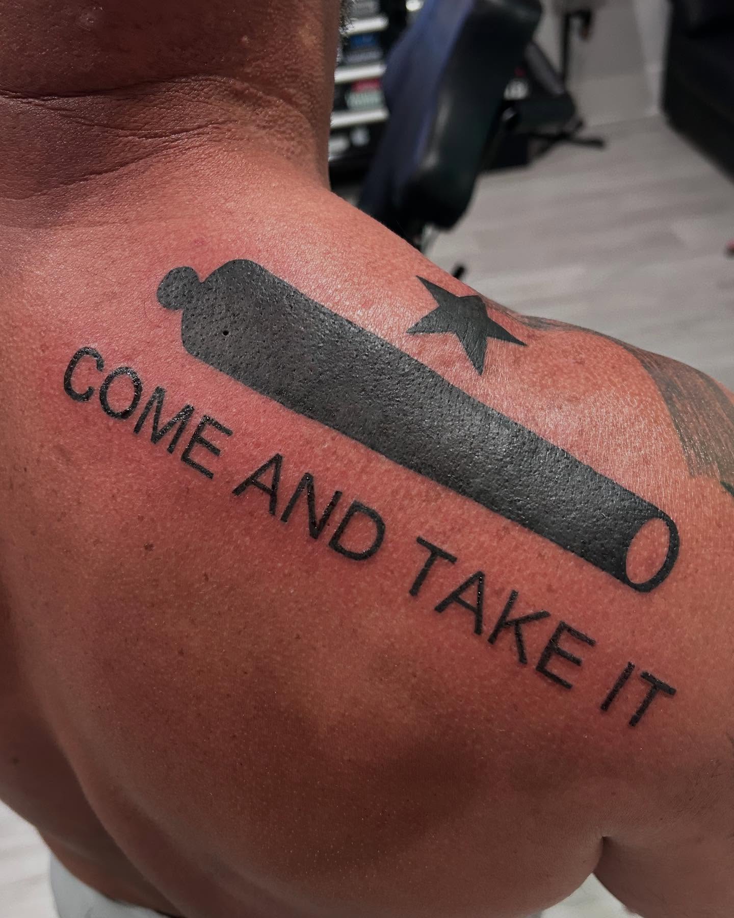 Come and Take It black and grey tattoo on the upper arm by Jbtattoo Artistry