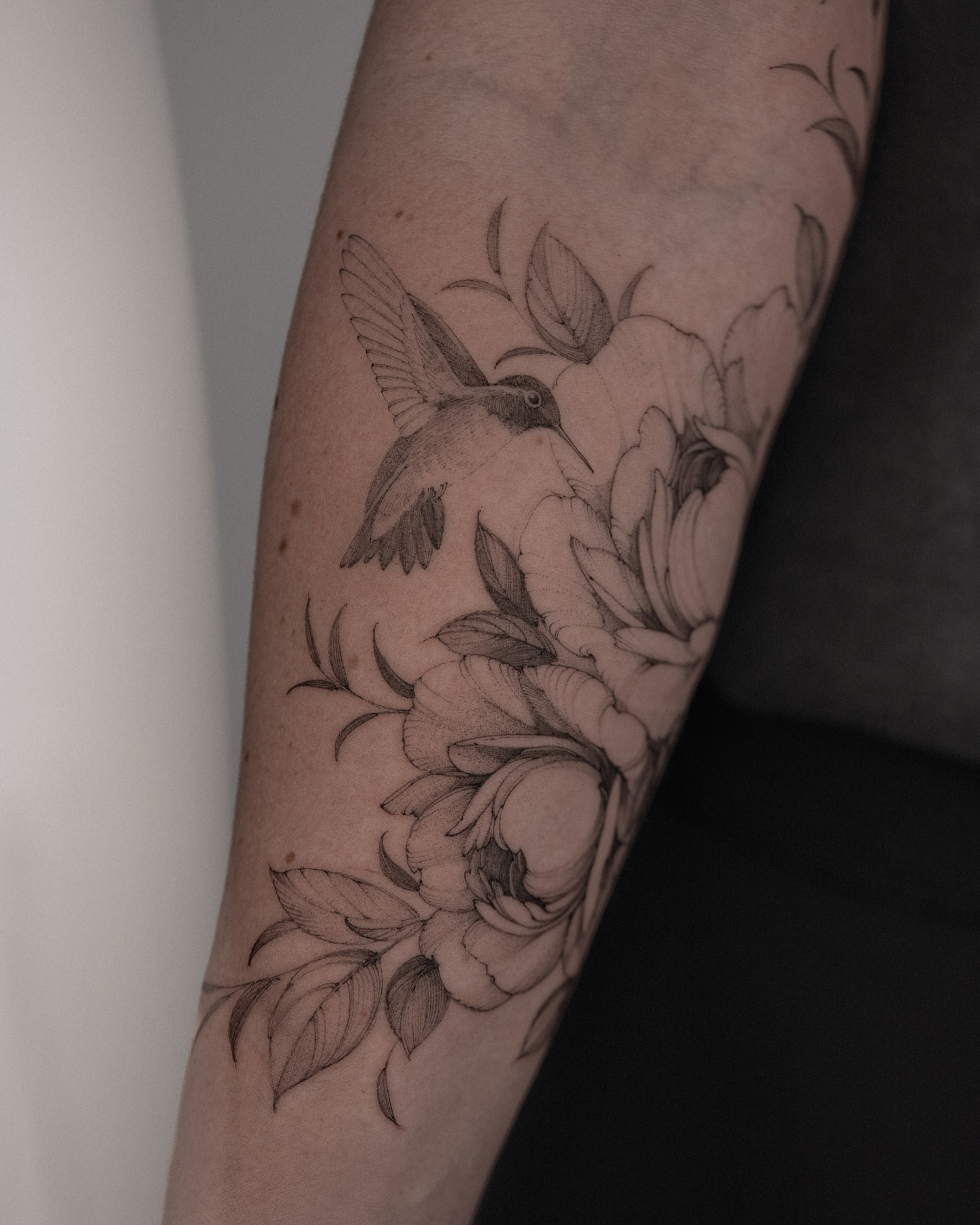 Hummingbird and flowers realism tattoo on the forearm by Mary Shekh