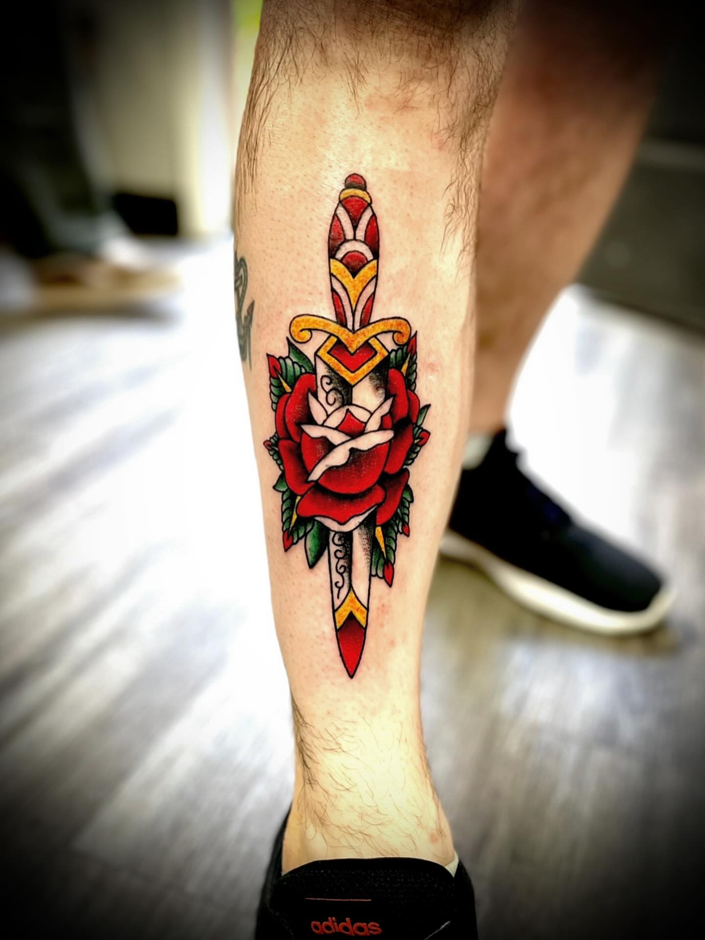 Sword and rose American traditional tattoo on the calf by JD Bassett