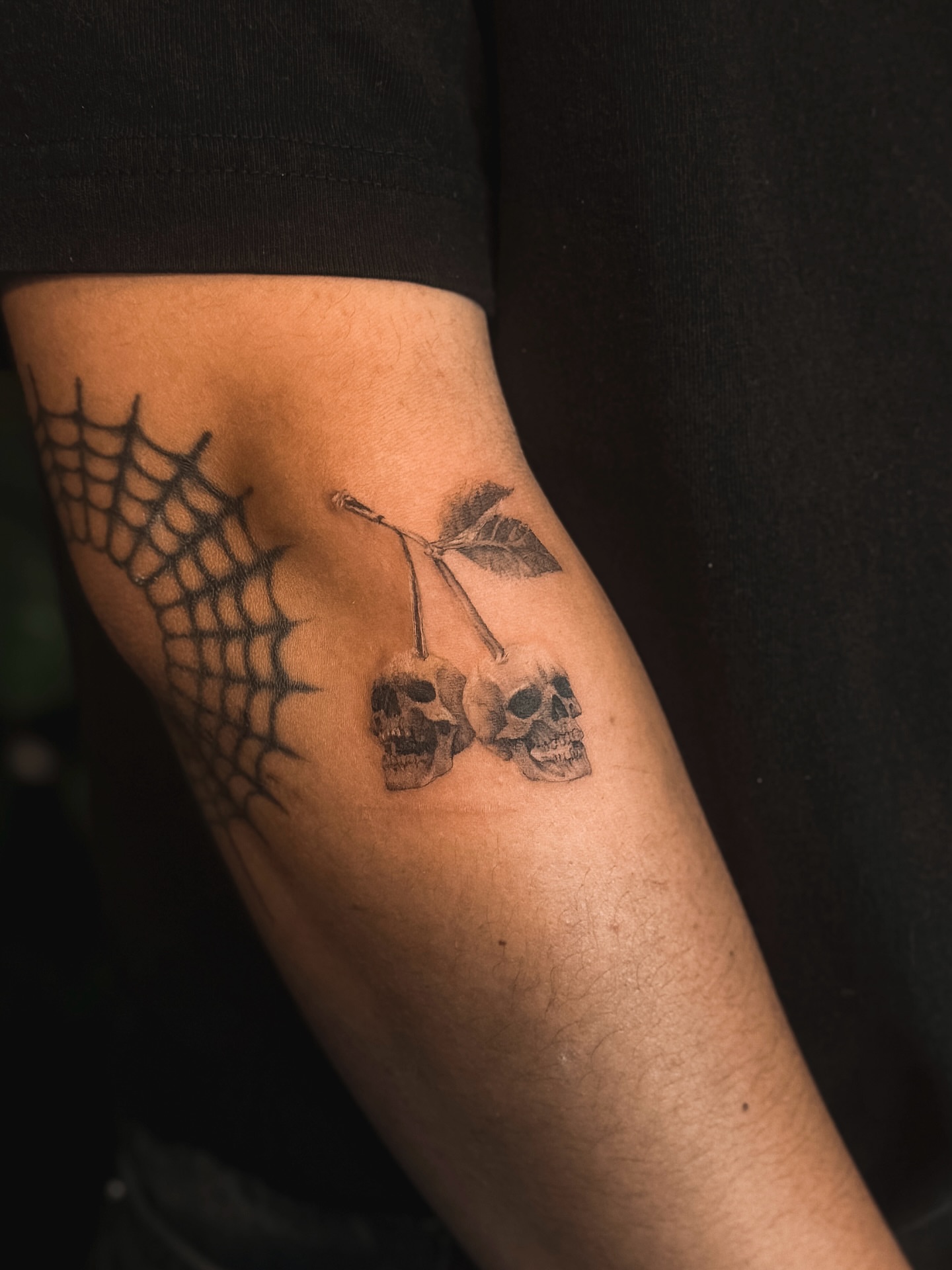 Cherry skulls black and grey tattoo on the forearm by Rose