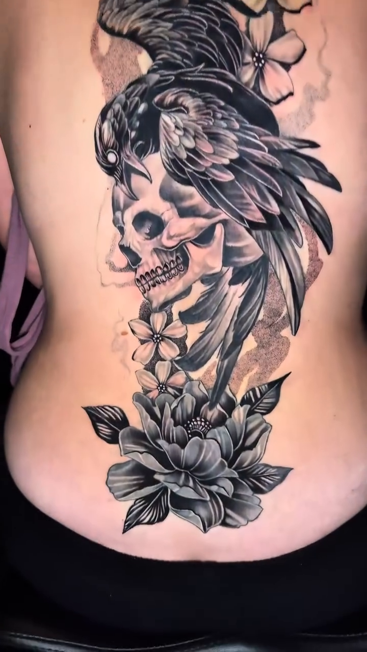 Skull with raven and flowers dark realism tattoo by Travis Sleeper
