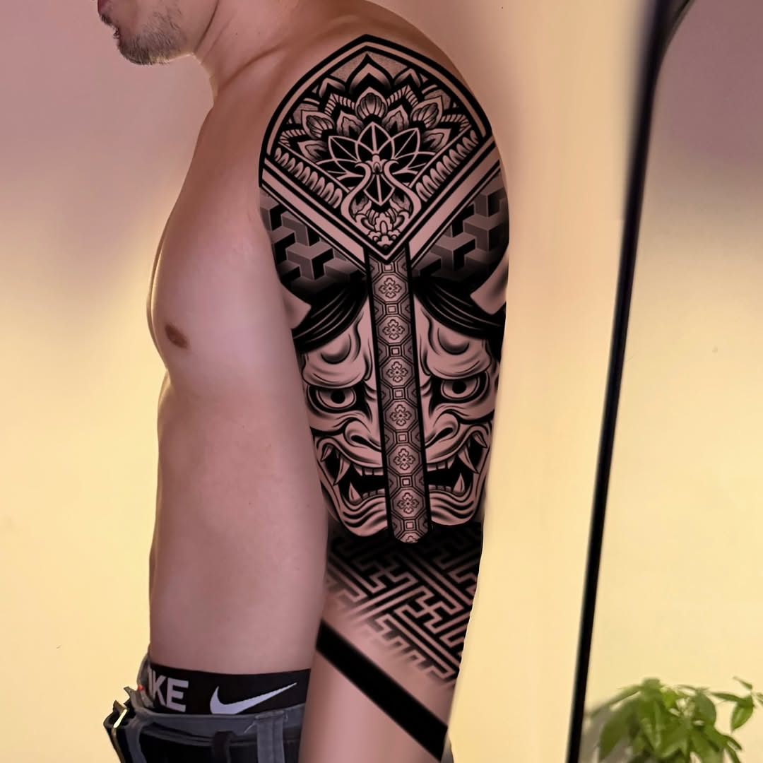 Oni mask and mandala Japanese tattoo on the upper arm by Ivy lee