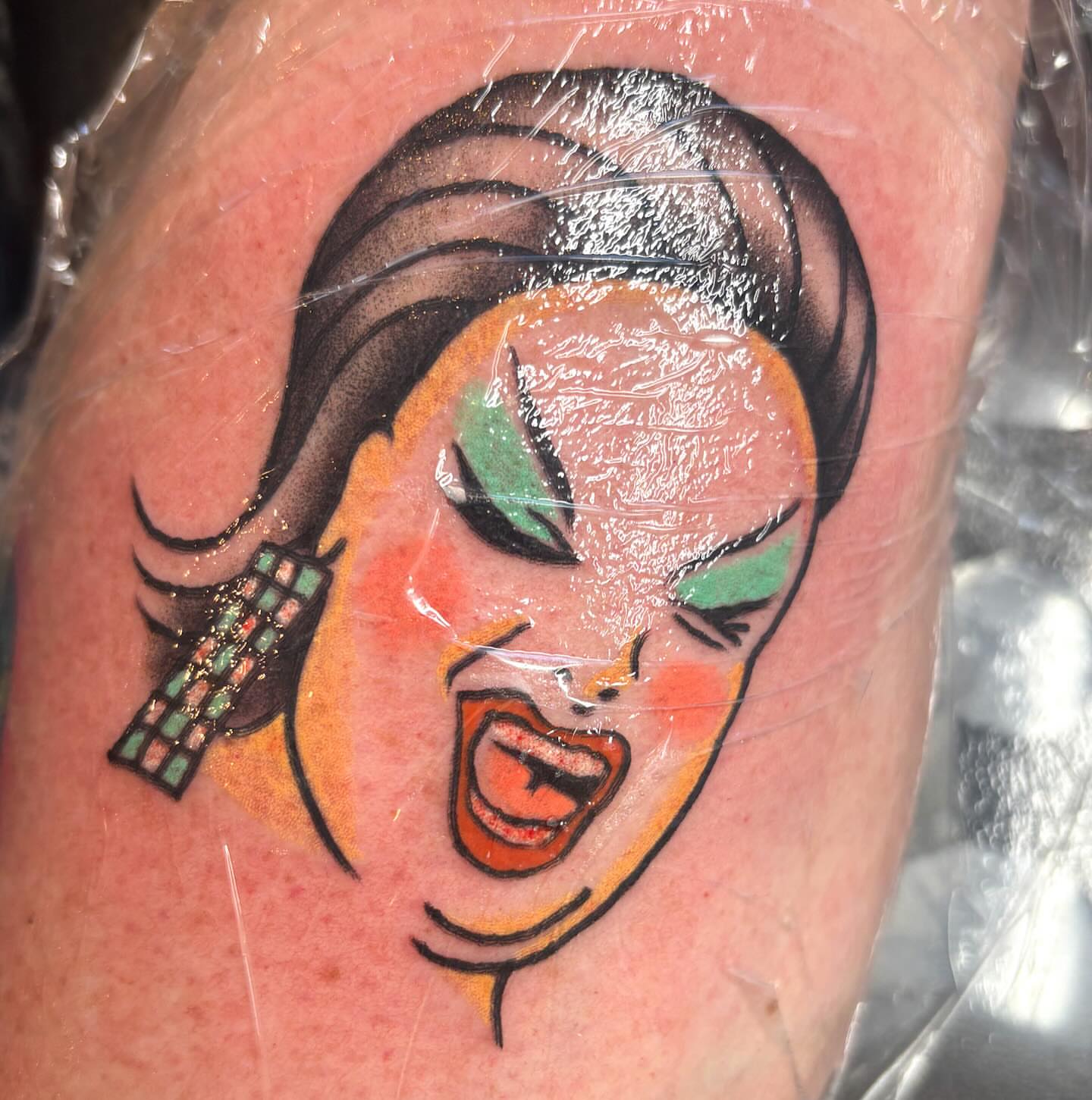 Woman with dramatic makeup American traditional tattoo on the forearm by Katelyn Spence